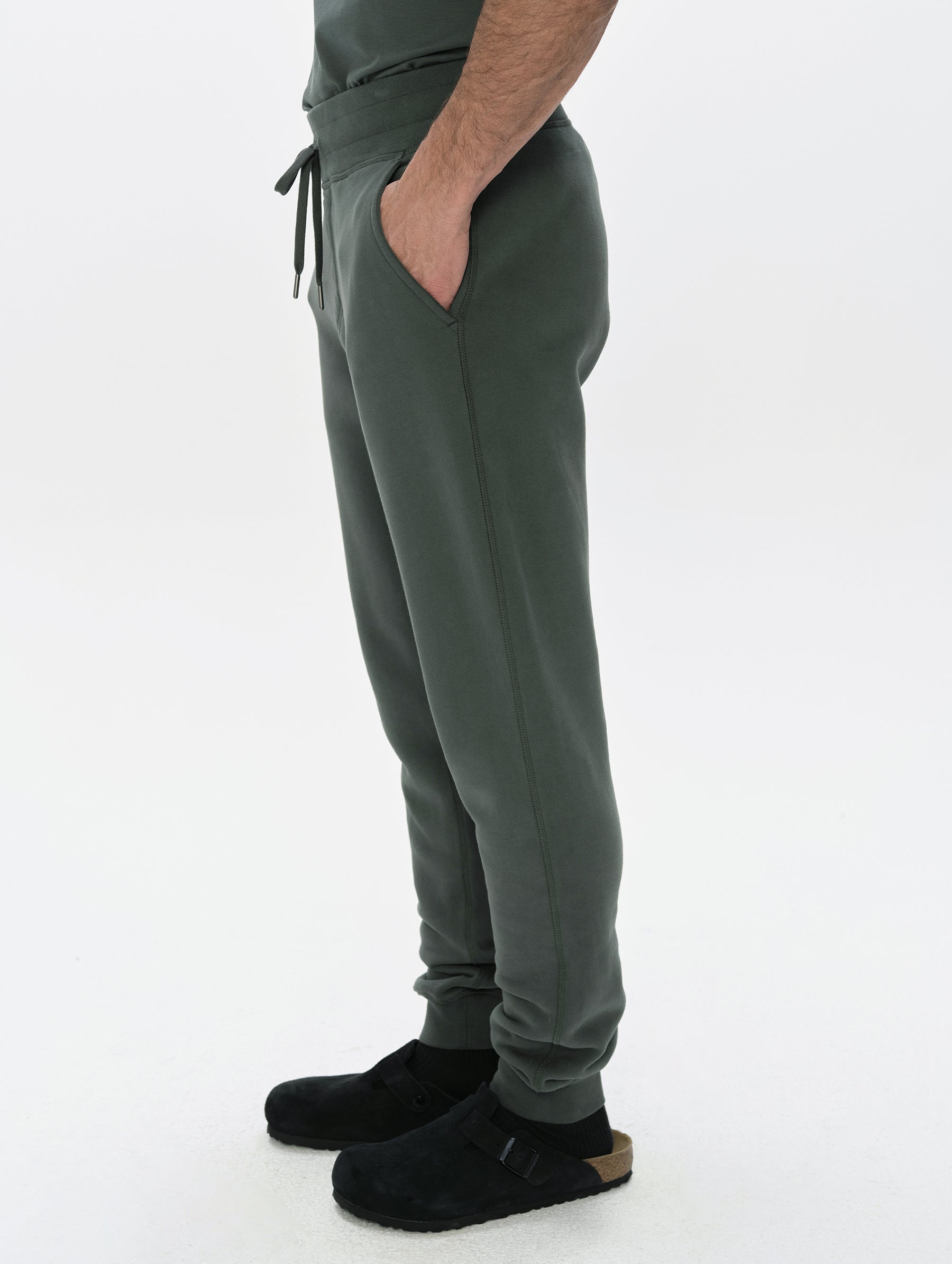 Side profile, lower-body view of man wearing the Rylan Cuffed Sweatpant in Saville Green  from AETHER Apparel.