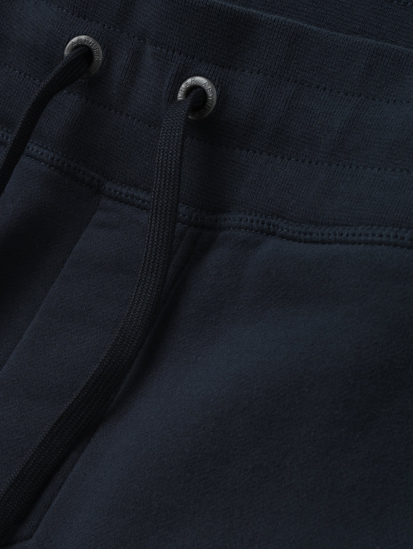 Closeup detailed view of the drawstring closure on the Rylan Cuffed Sweatpant in Total Eclipse from AETHER Apparel.
