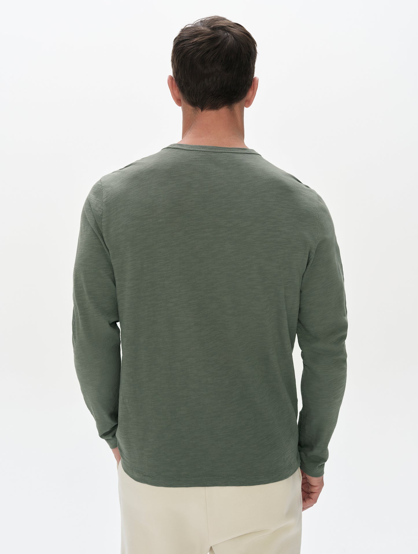 Rear, upper-body view of man wearing the Slub Pocket Long-Sleeve Tee 2.0 in Gunmetal from AETHER Apparel.