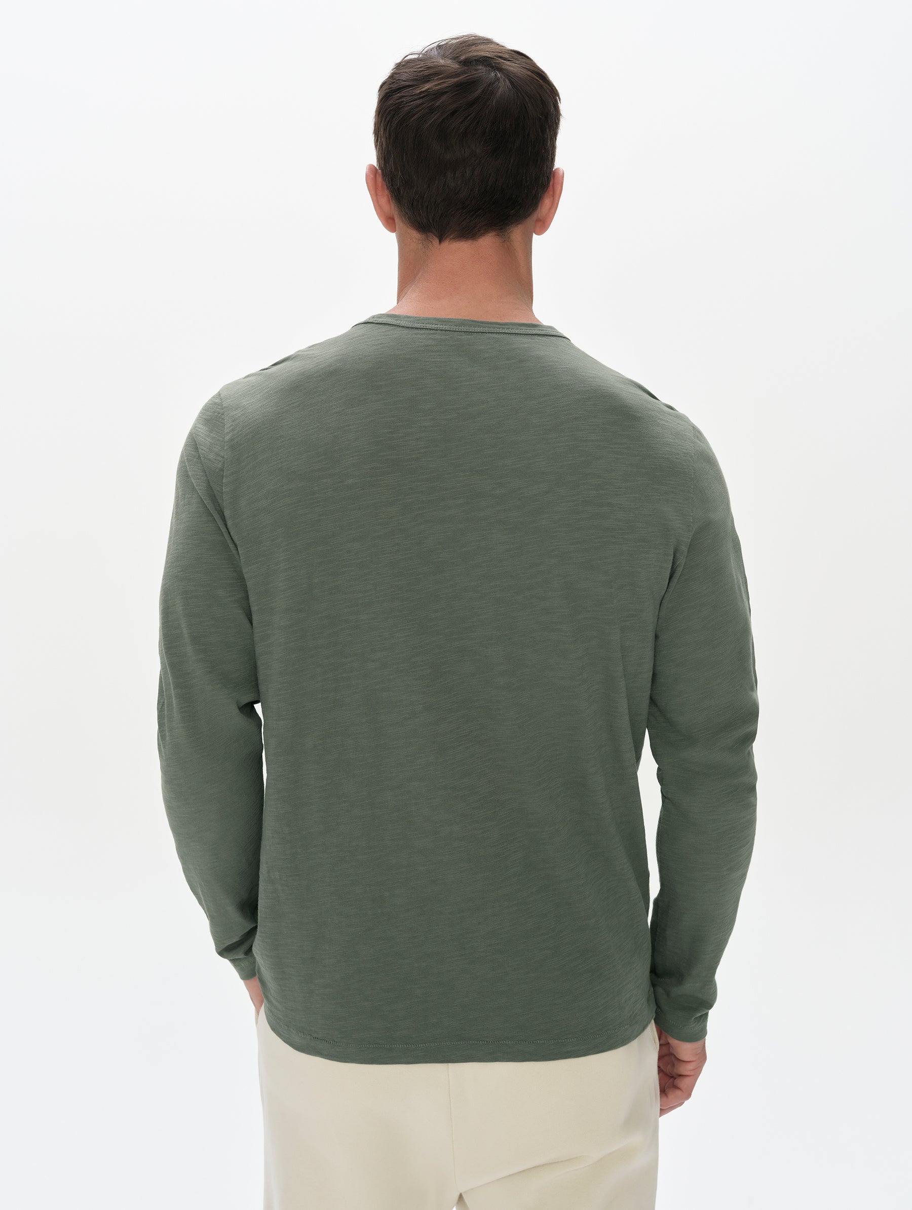 Rear, upper-body view of man wearing the Slub Pocket Long-Sleeve Tee 2.0 in Gunmetal from AETHER Apparel.