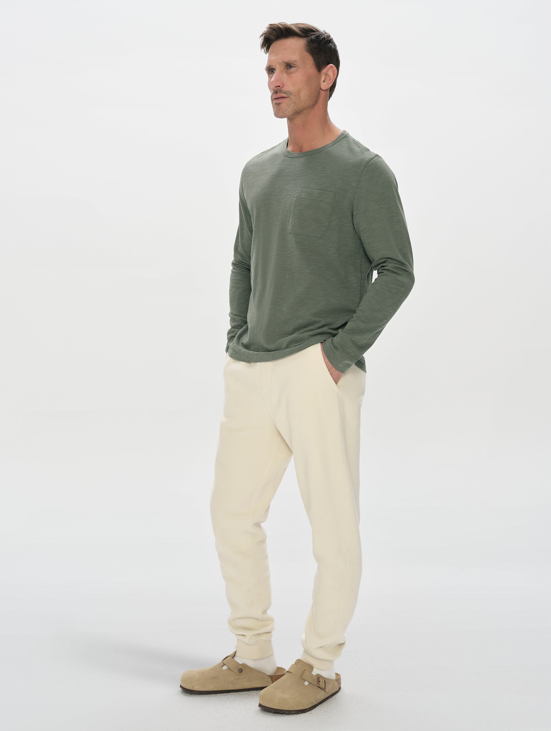 Front, 3/4, full-body view of man wearing the Slub Pocket Long-Sleeve Tee 2.0 in Gunmetal from AETHER Apparel.