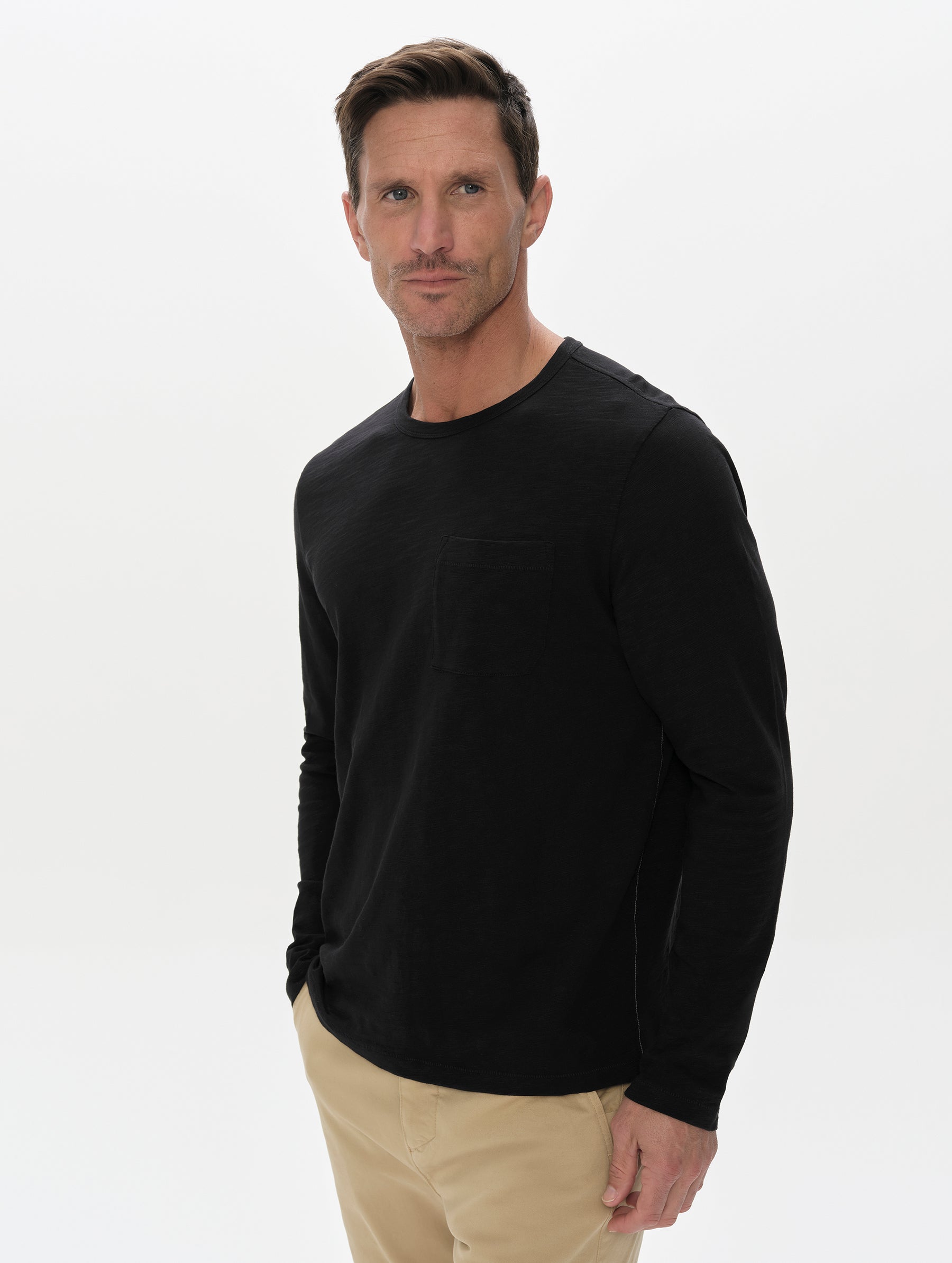 Front, upper-body view of man wearing the Slub Pocket Long-Sleeve Tee 2.0 in Onyx Black from AETHER Apparel.