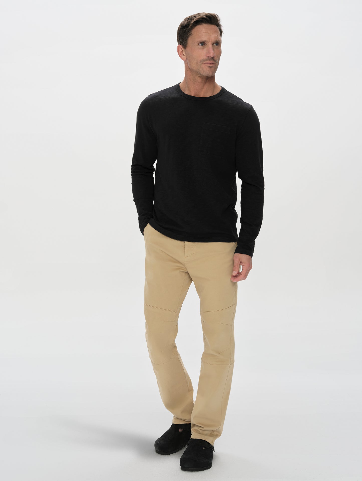 Front, full-body view of man wearing the Slub Pocket Long-Sleeve Tee 2.0 in Onyx Black from AETHER Apparel.