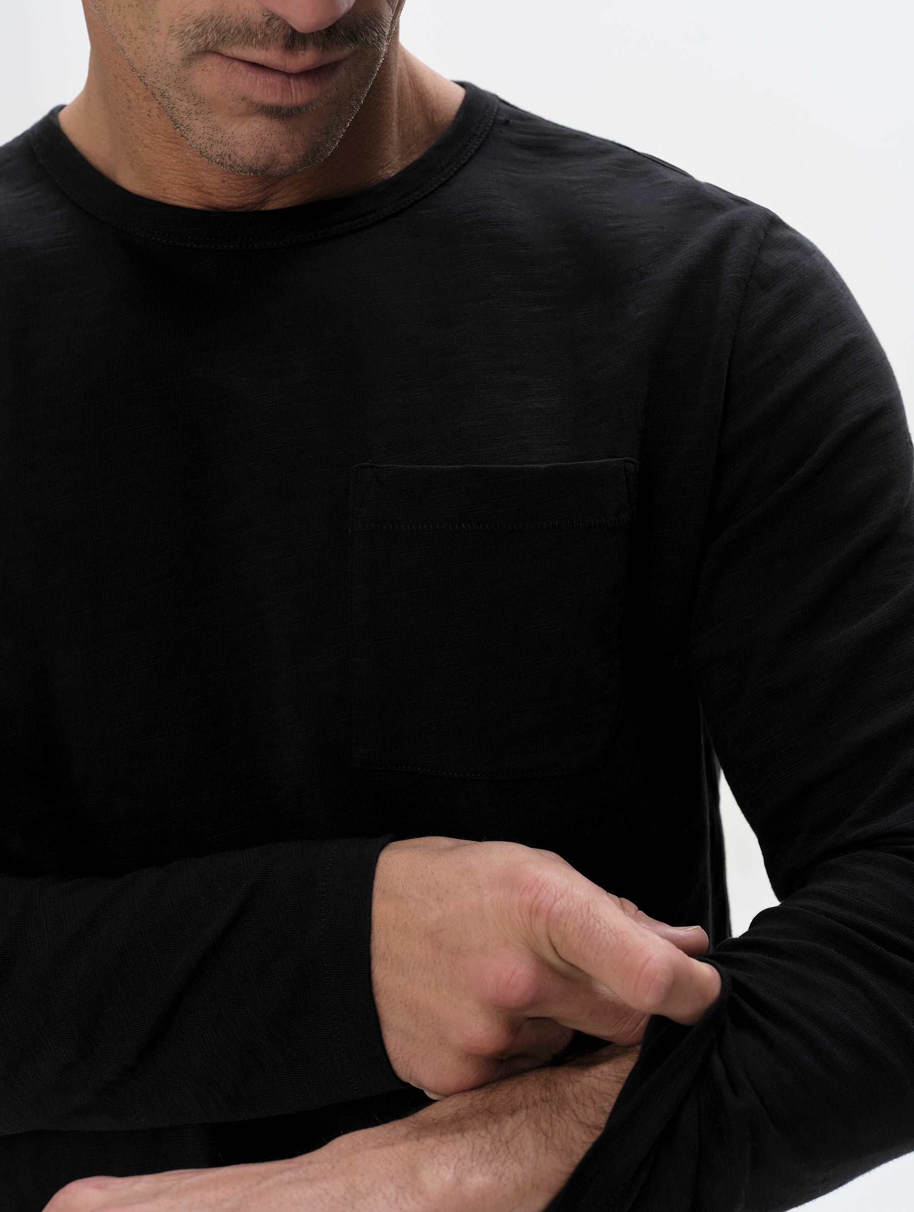 Closeup detailed view of the shoulder and patch pocket on the Slub Pocket Long-Sleeve Tee 2.0 in Onyx Black from AETHER Apparel.