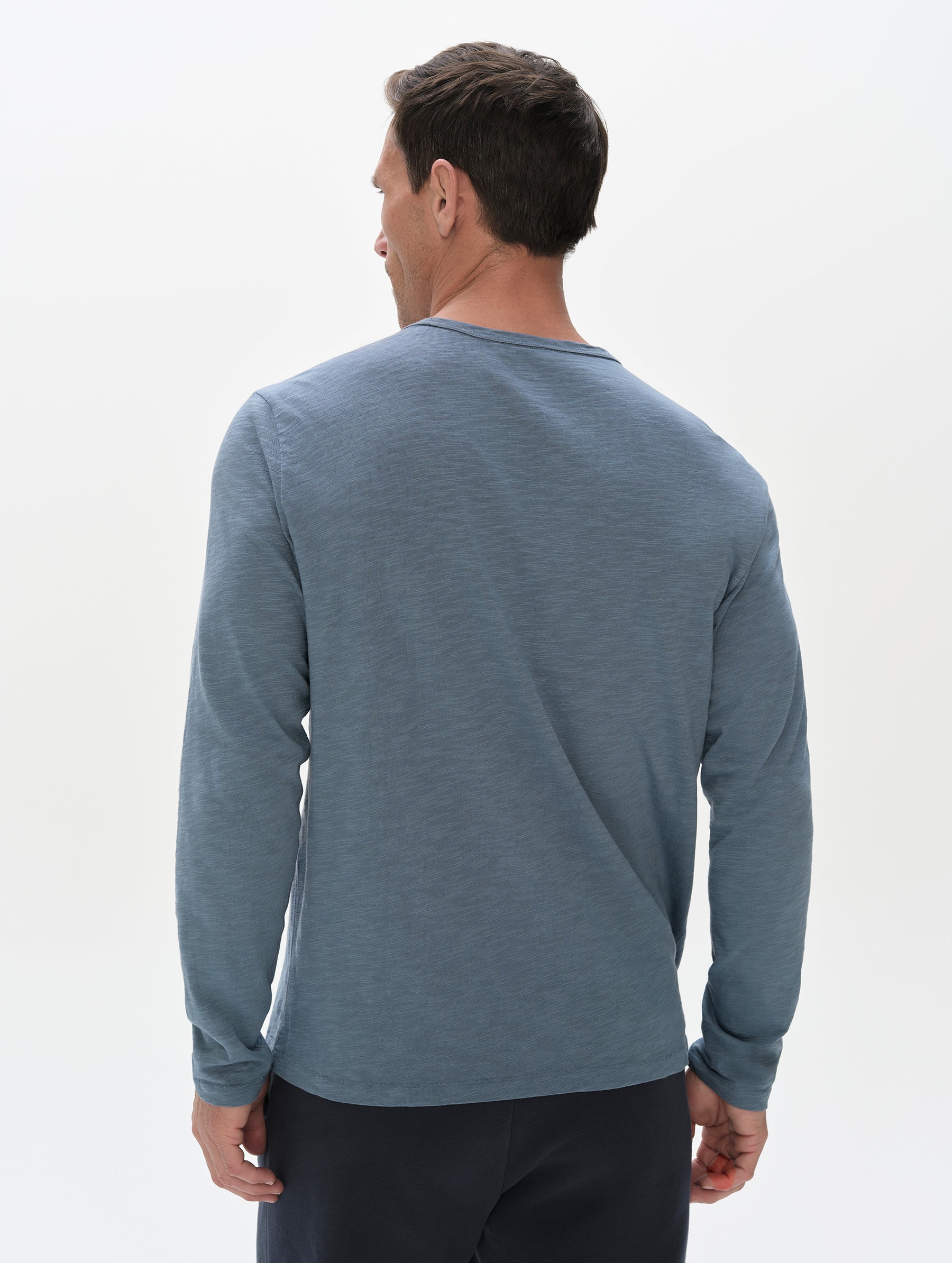 Rear, upper-body view of man wearing the Slub Pocket Long-Sleeve Tee 2.0 in Portal Blue from AETHER Apparel.