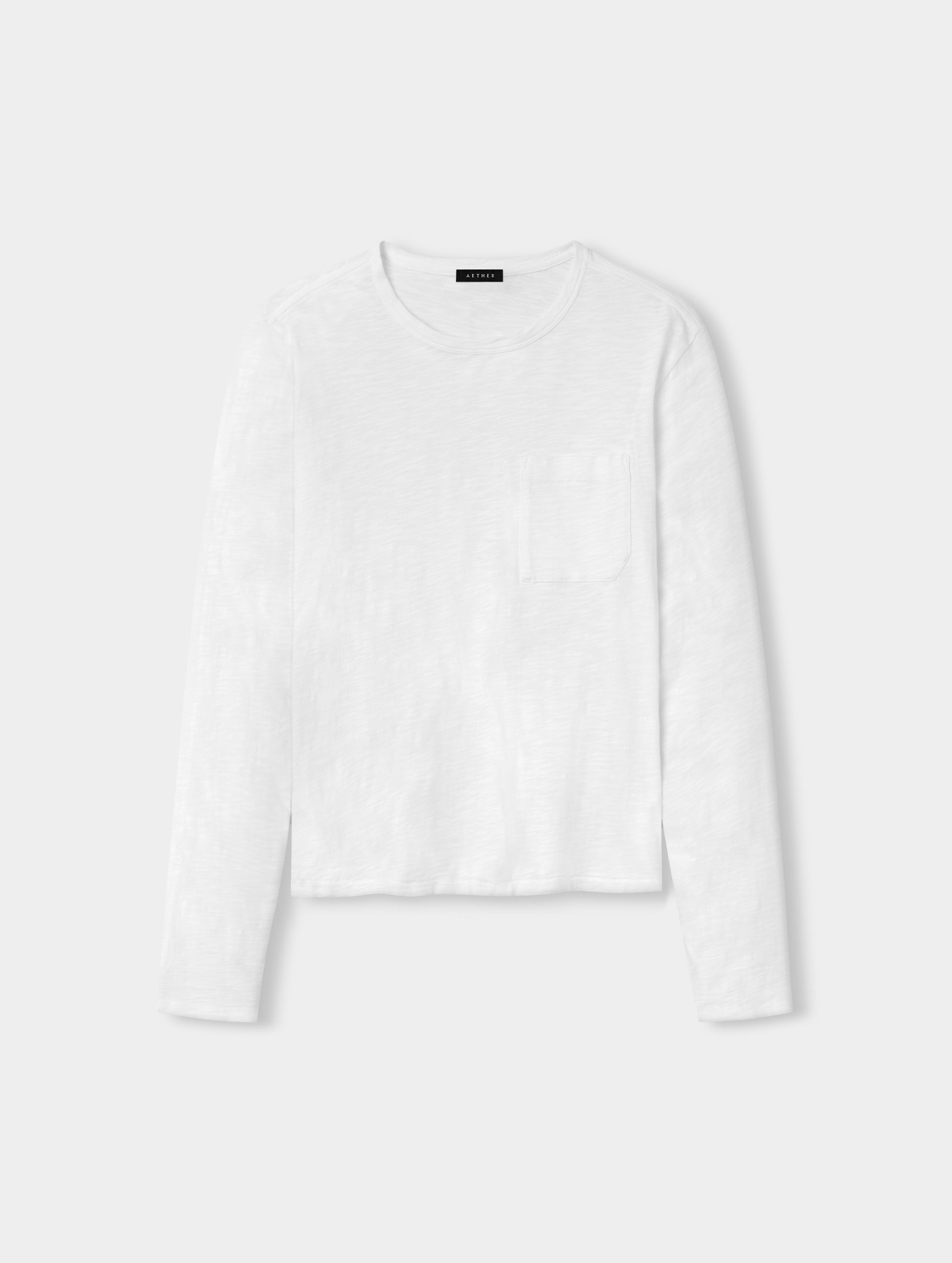 Front, full-body view of man wearing Slub Long-Sleeve Pocket Tee 2.0 in White from AETHER Apparel.