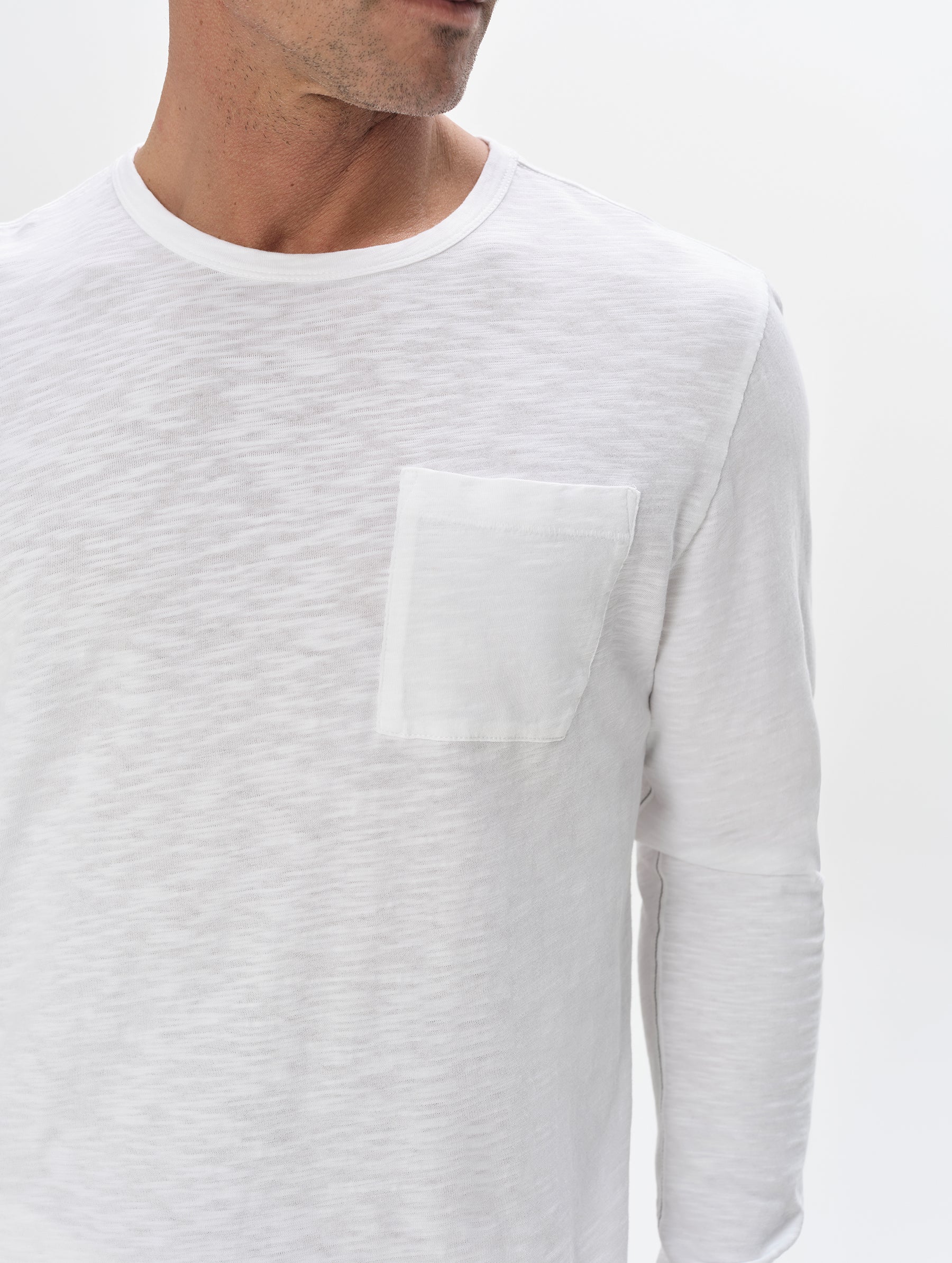 Closeup detailed view of the chest pocket and shoulder on the Slub Long-Sleeve Pocket Tee 2.0 in White from AETHER Apparel.