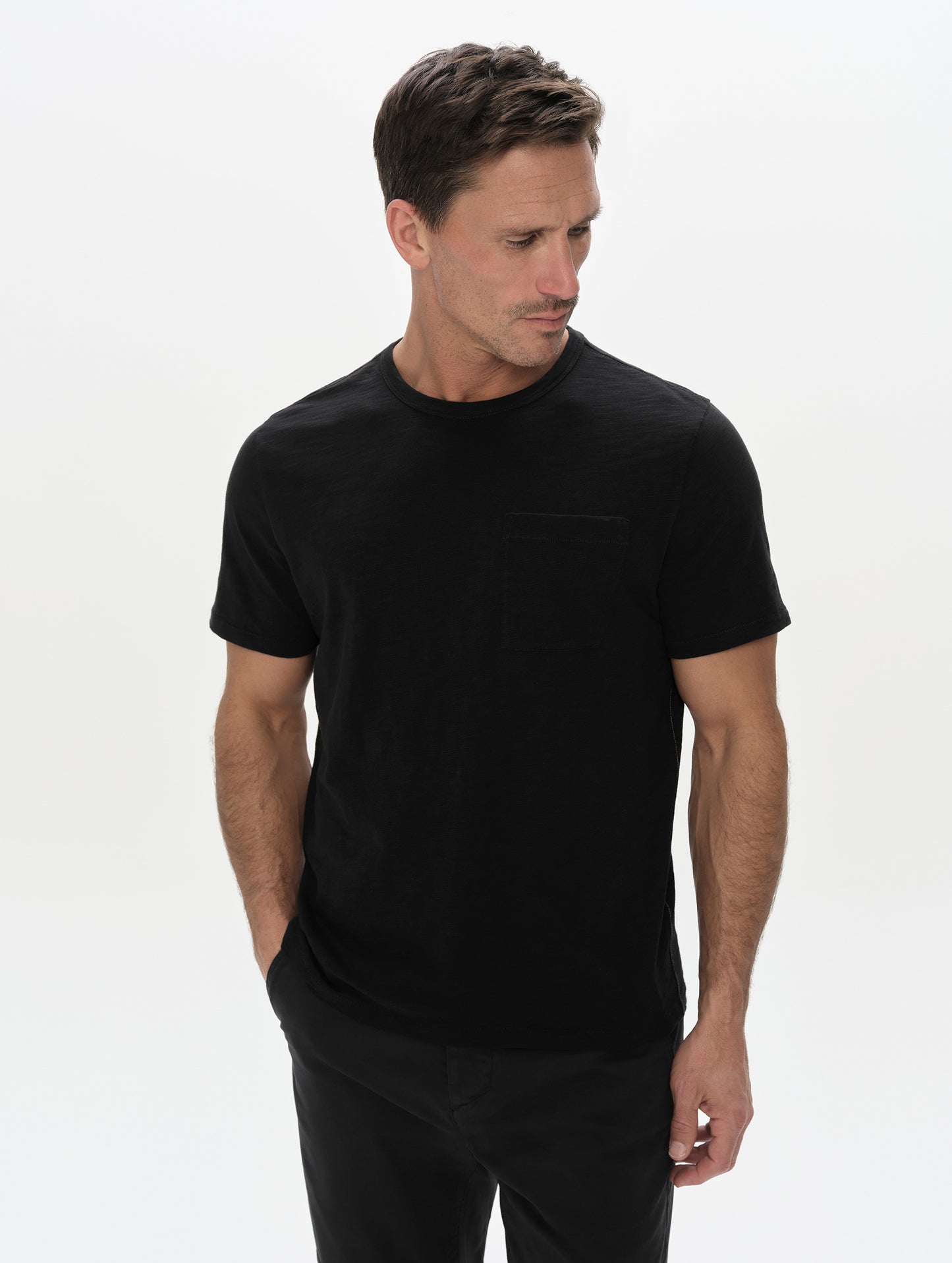 Front, upper-body view of man wearing the Slub Pocket Tee 2.0 in Onyx Black from AETHER Apparel.