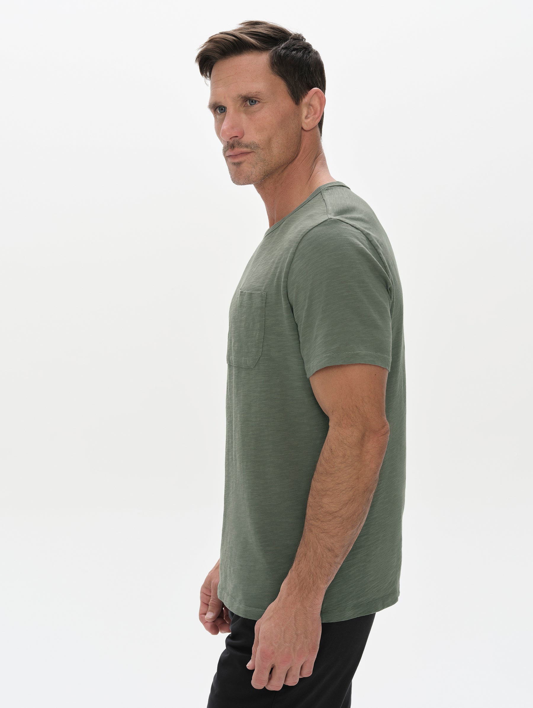 Side profile, upper-body view of man wearing the Slub Pocket Tee 2.0 in Gunmetal from AETHER Apparel.
