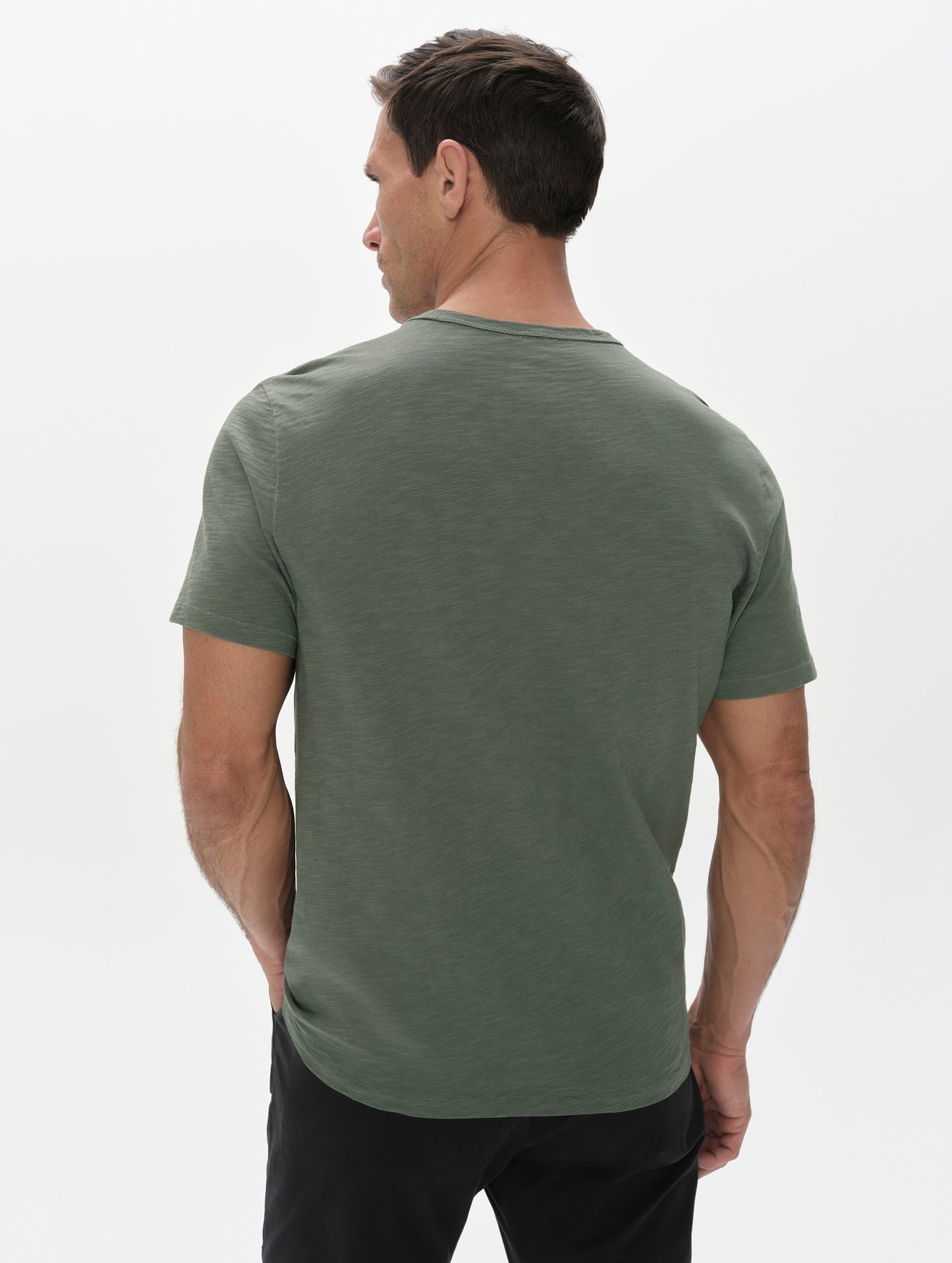 Rear, upper-body view of man wearing the Slub Pocket Tee 2.0 in Gunmetal from AETHER Apparel.