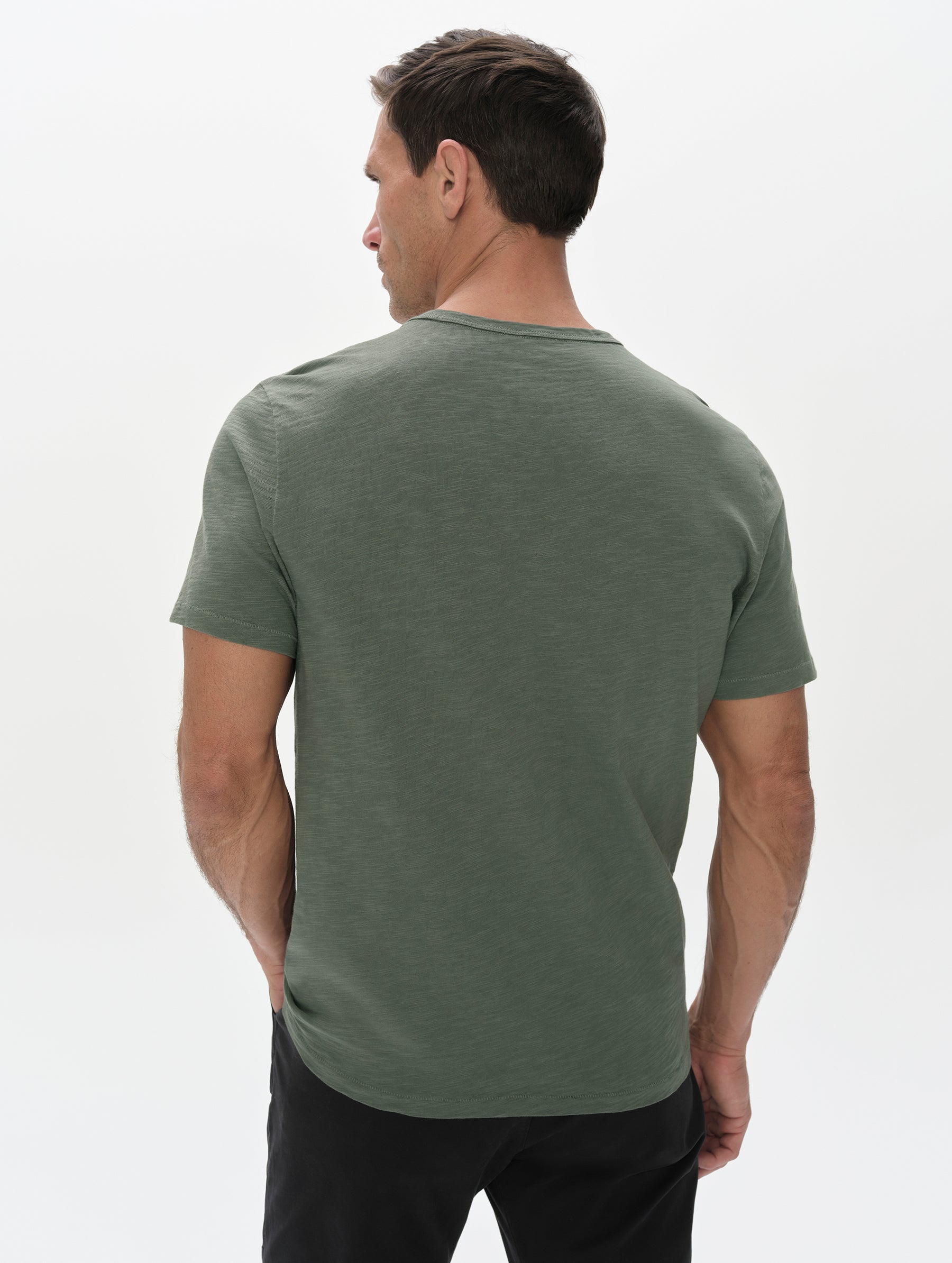 Rear, upper-body view of man wearing the Slub Pocket Tee 2.0 in Gunmetal from AETHER Apparel.