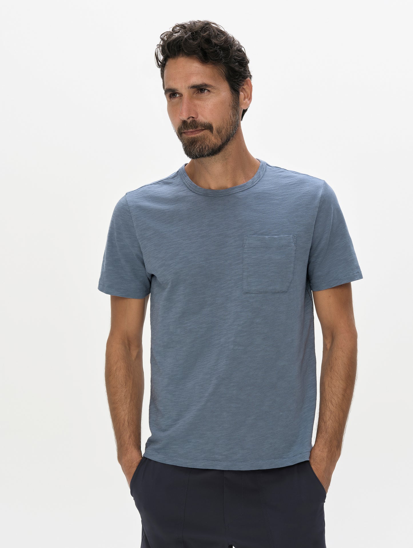 Front, upper-body view of man wearing the Slub Pocket Tee 2.0 in Portal Blue from AETHER Apparel.