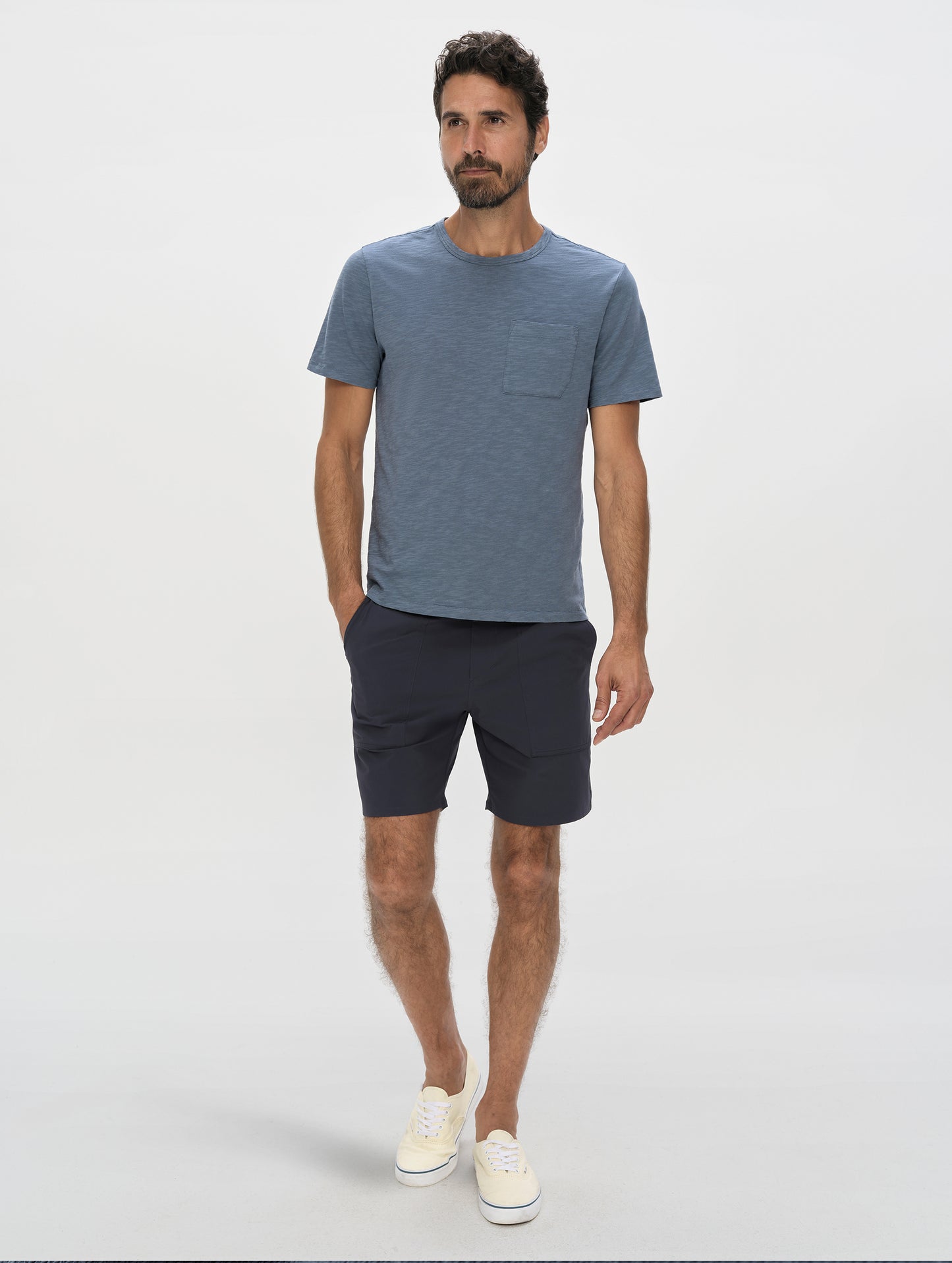 Front, full-body view of man wearing the Slub Pocket Long-Sleeve Tee 2.0 in Portal Blue from AETHER Apparel.