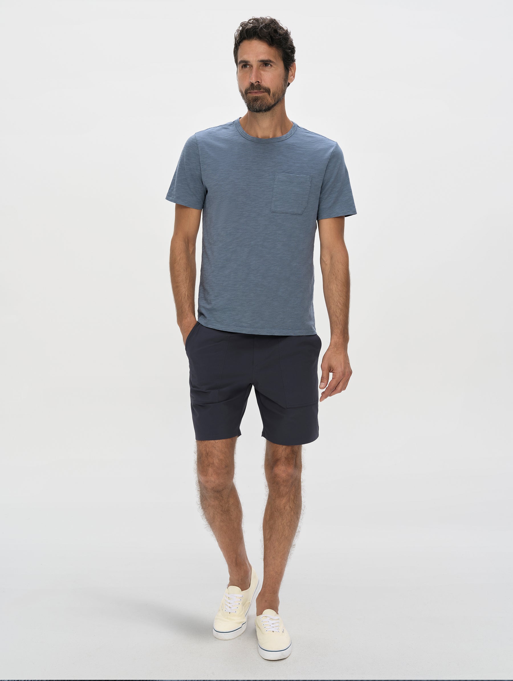 Front, full-body view of man wearing the Slub Pocket Long-Sleeve Tee 2.0 in Portal Blue from AETHER Apparel.