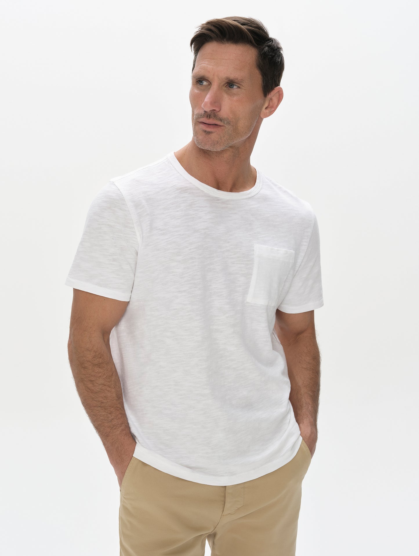 Front, upper-body view of man wearing Slub Pocket Tee 2.0 in White from AETHER Apparel.