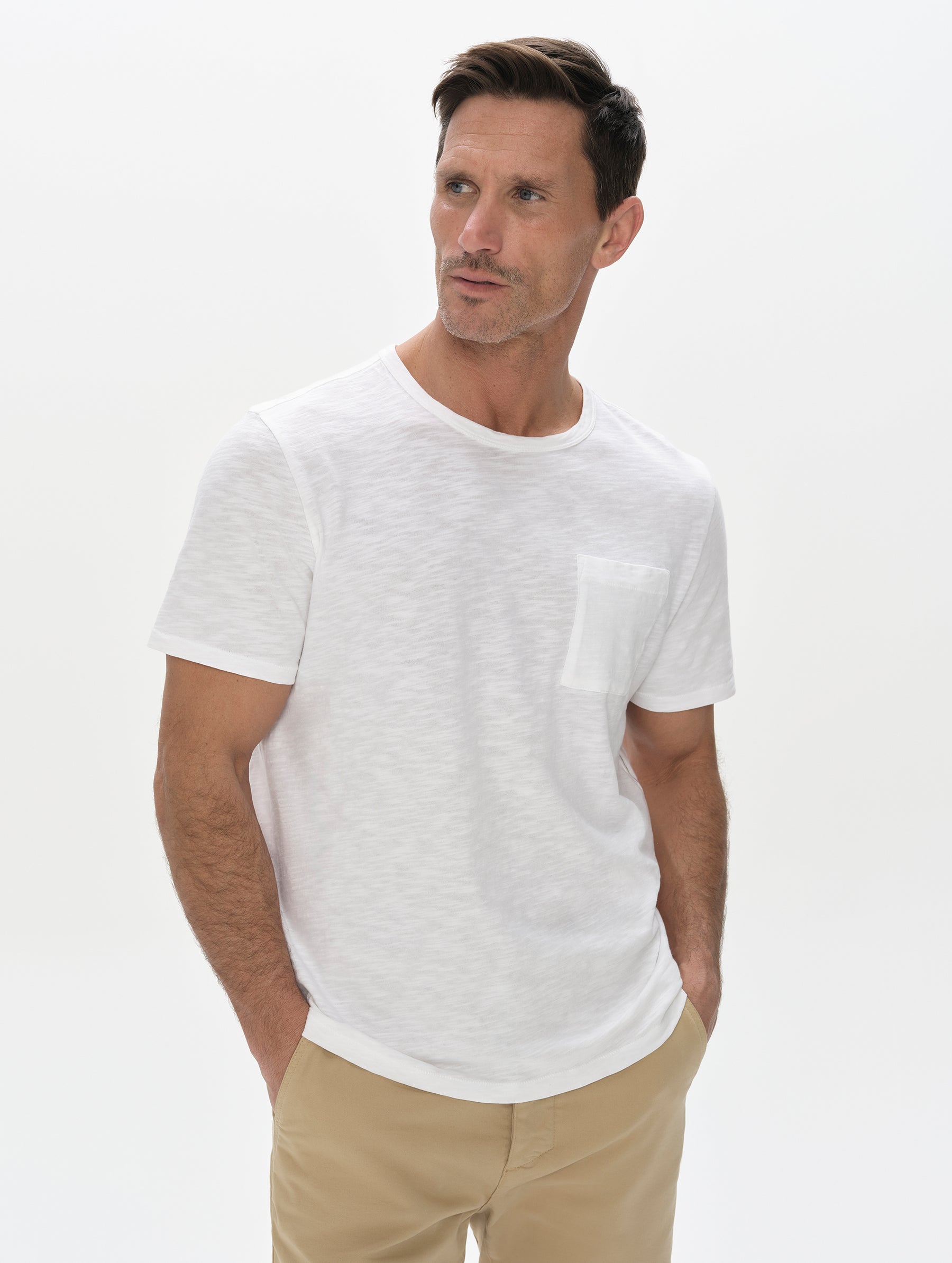 Front, upper-body view of man wearing Slub Pocket Tee 2.0 in White from AETHER Apparel.
