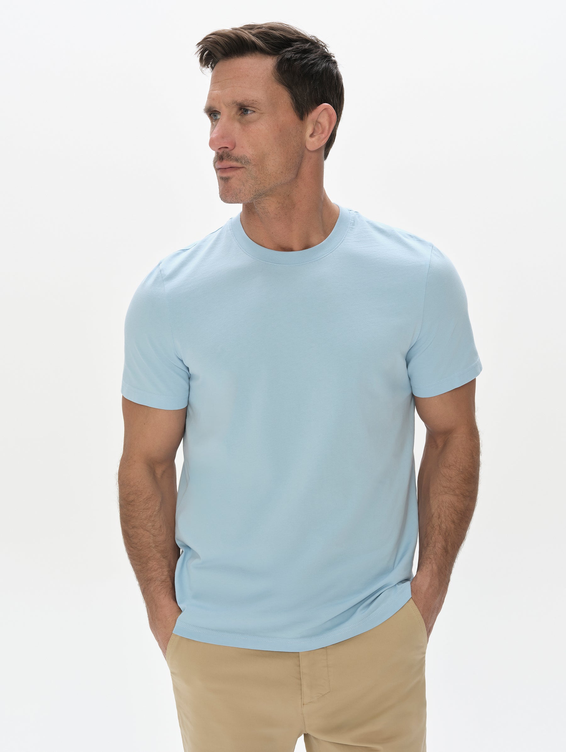 Front, upper-body view of man wearing the Standard Tee in Cloud Blue from AETHER Apparel.
