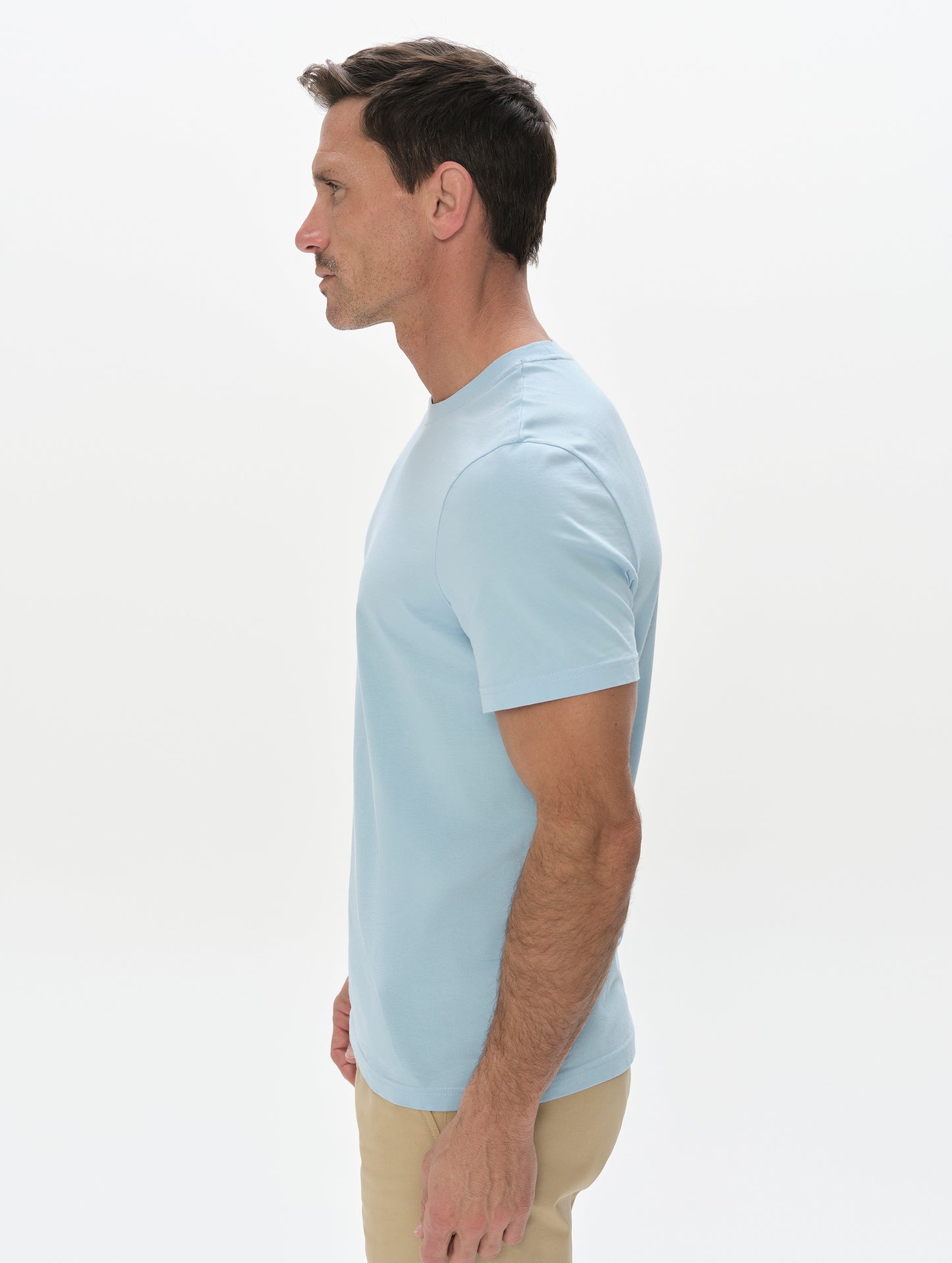 Side profile, upper-body view of man wearing the Standard Tee in Cloud Blue from AETHER Apparel.