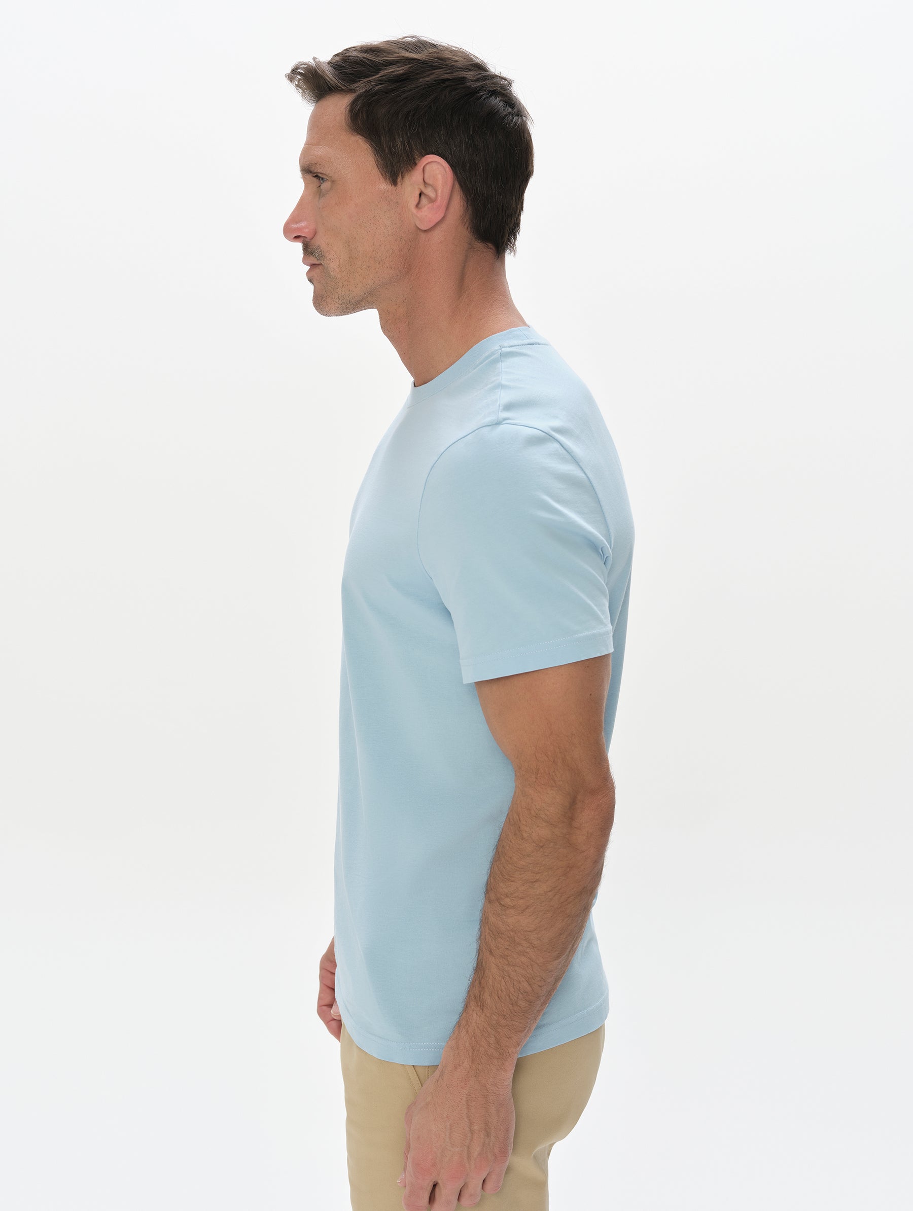 Side profile, upper-body view of man wearing the Standard Tee in Cloud Blue from AETHER Apparel.