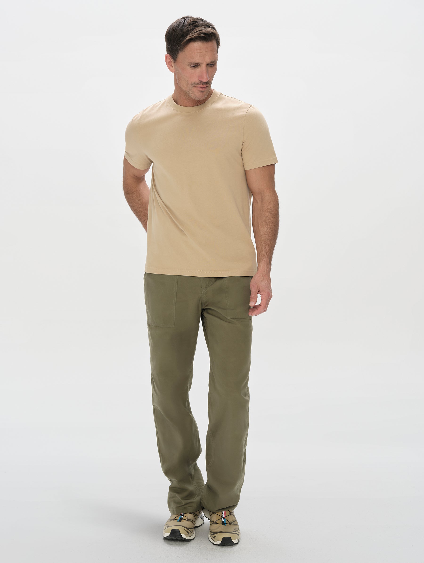 Front, full-body view of man wearing the Standard Tee in Desert Tan from AETHER Apparel.