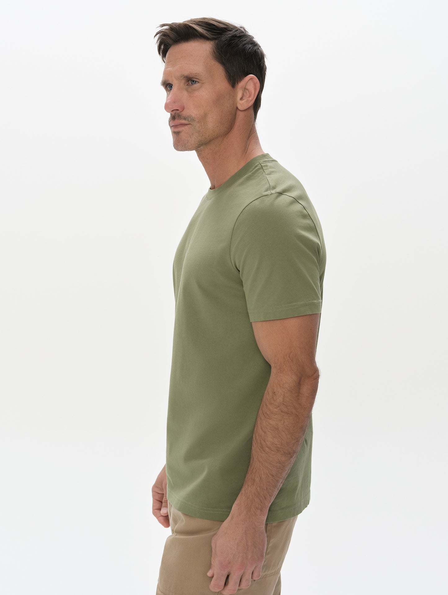Side profile, upper-body view of man wearing the Standard Tee in Fern Green from AETHER Apparel.