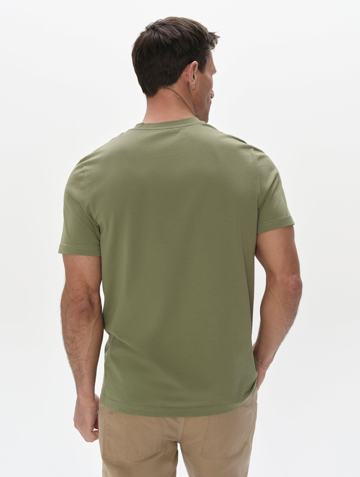 Rear, upper-body view of man wearing the Standard Tee in Fern Green from AETHER Apparel.