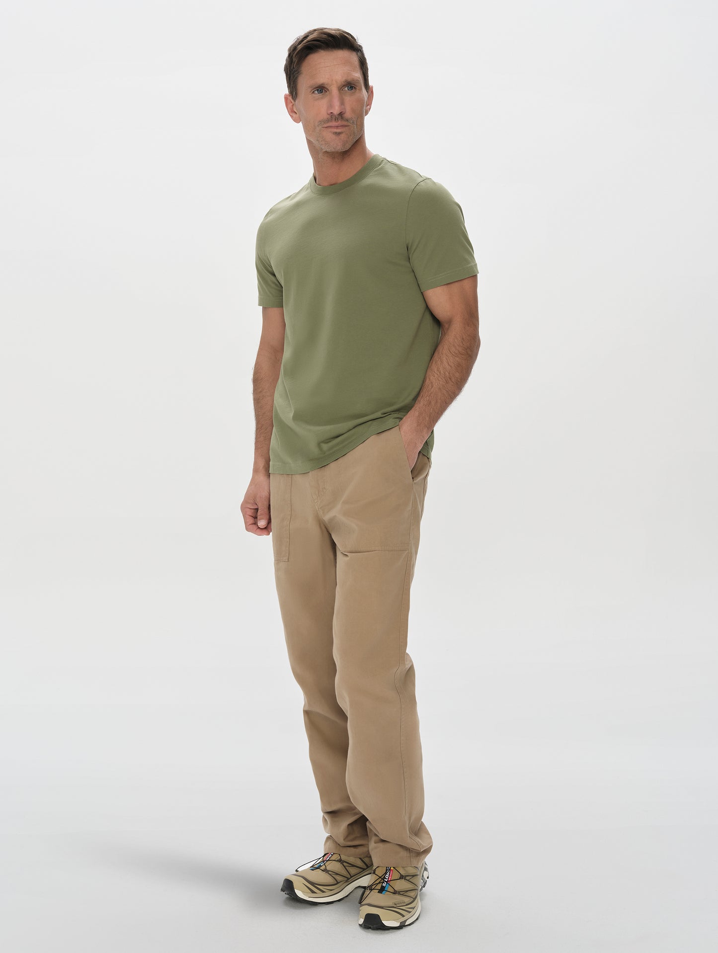 Front, 3/4, full-body view of man wearing the Standard Tee in Fern Green from AETHER Apparel.