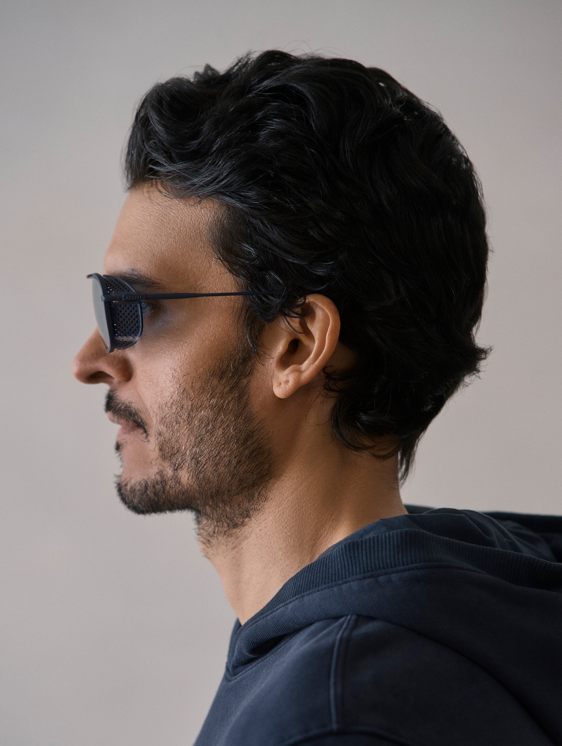 Side profile view of man wearing Summit Sunglass in Blue titanium with Blue Lens from AETHER Apparel.