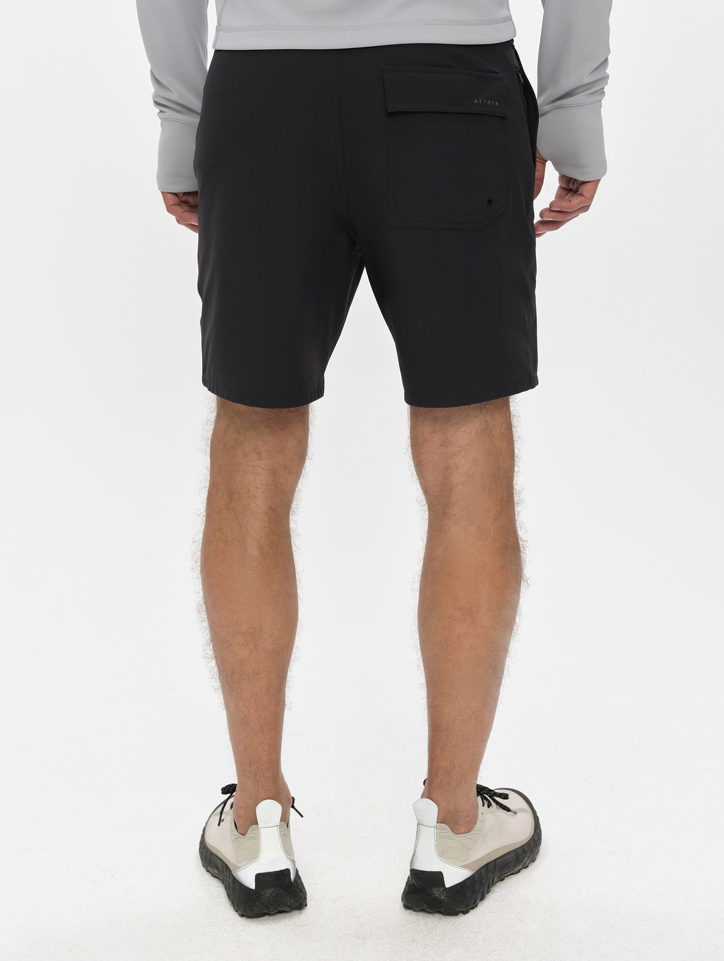 Rear, lower-body view of man wearing the Velo Short in Onyx Black from AETHER Apparel.