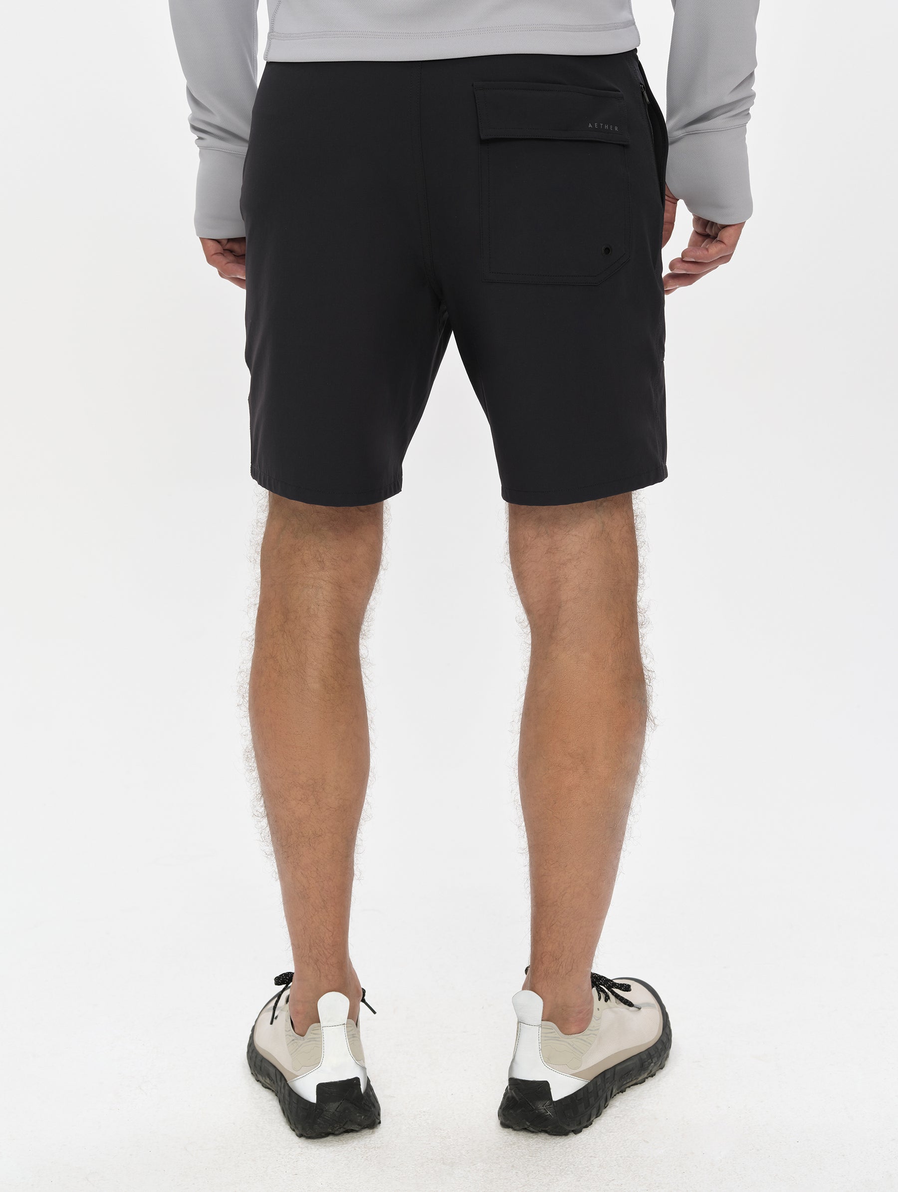 Rear, lower-body view of man wearing the Velo Short in Onyx Black from AETHER Apparel.