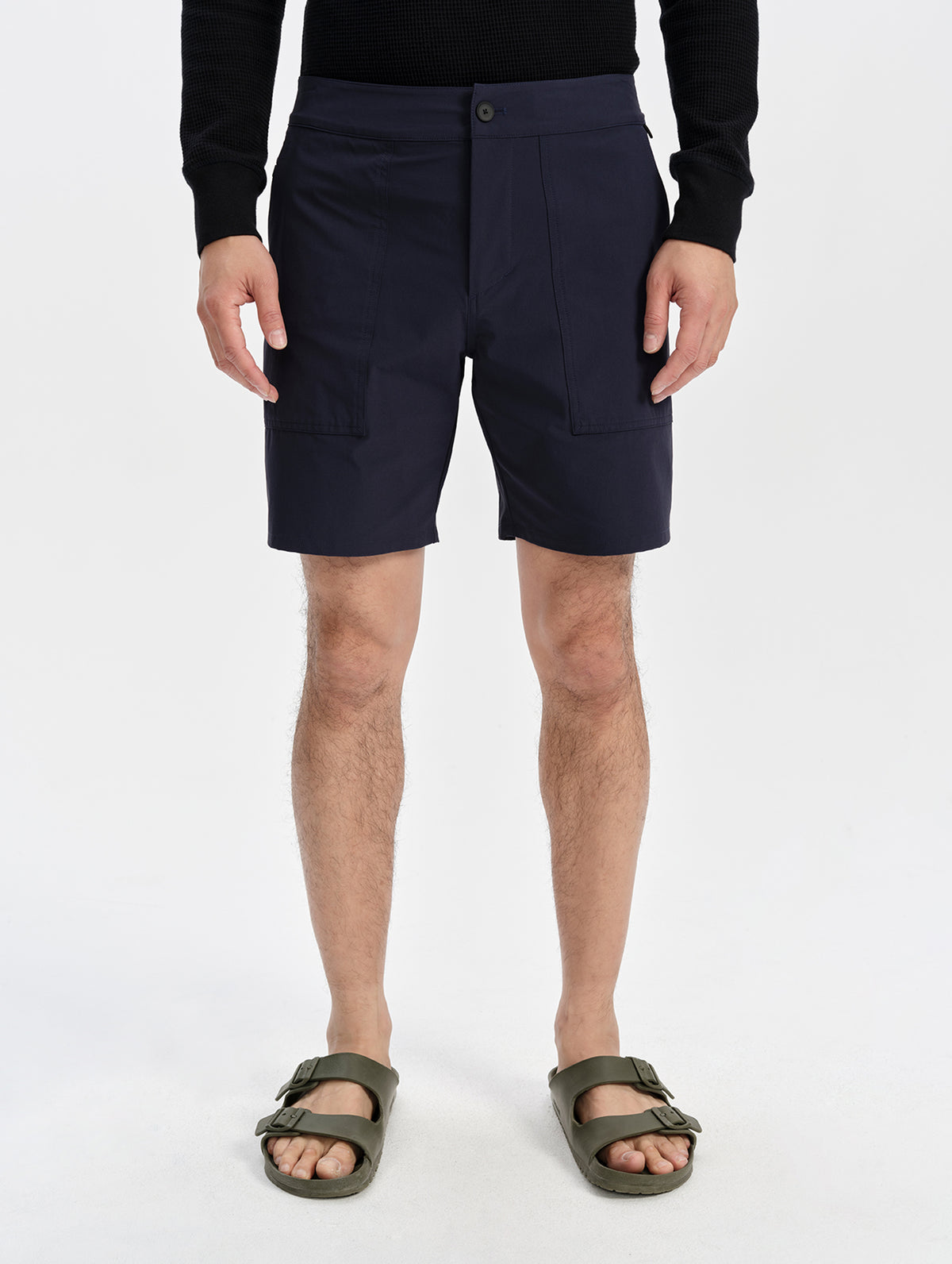 Lower-body front view of a model wearing the men’s Velo Short in Total Eclipse, showing the field hand pockets.