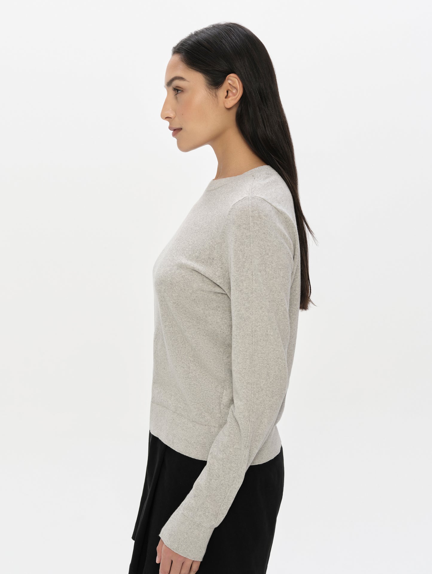 Side profile upper-body view of woman wearing the Aero Crewneck Sweater 2.0 in Alumino Grey from AETHER Apparel.