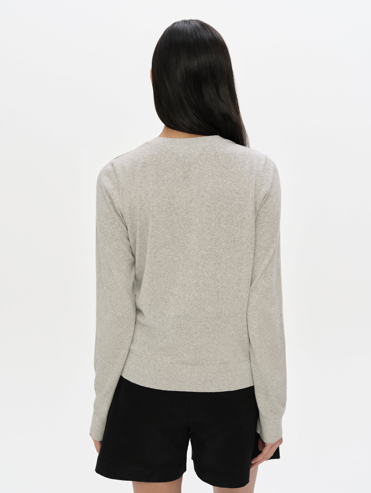 Rear upper-body view of woman wearing the Aero Crewneck Sweater 2.0 in Alumino Grey from AETHER Apparel.
