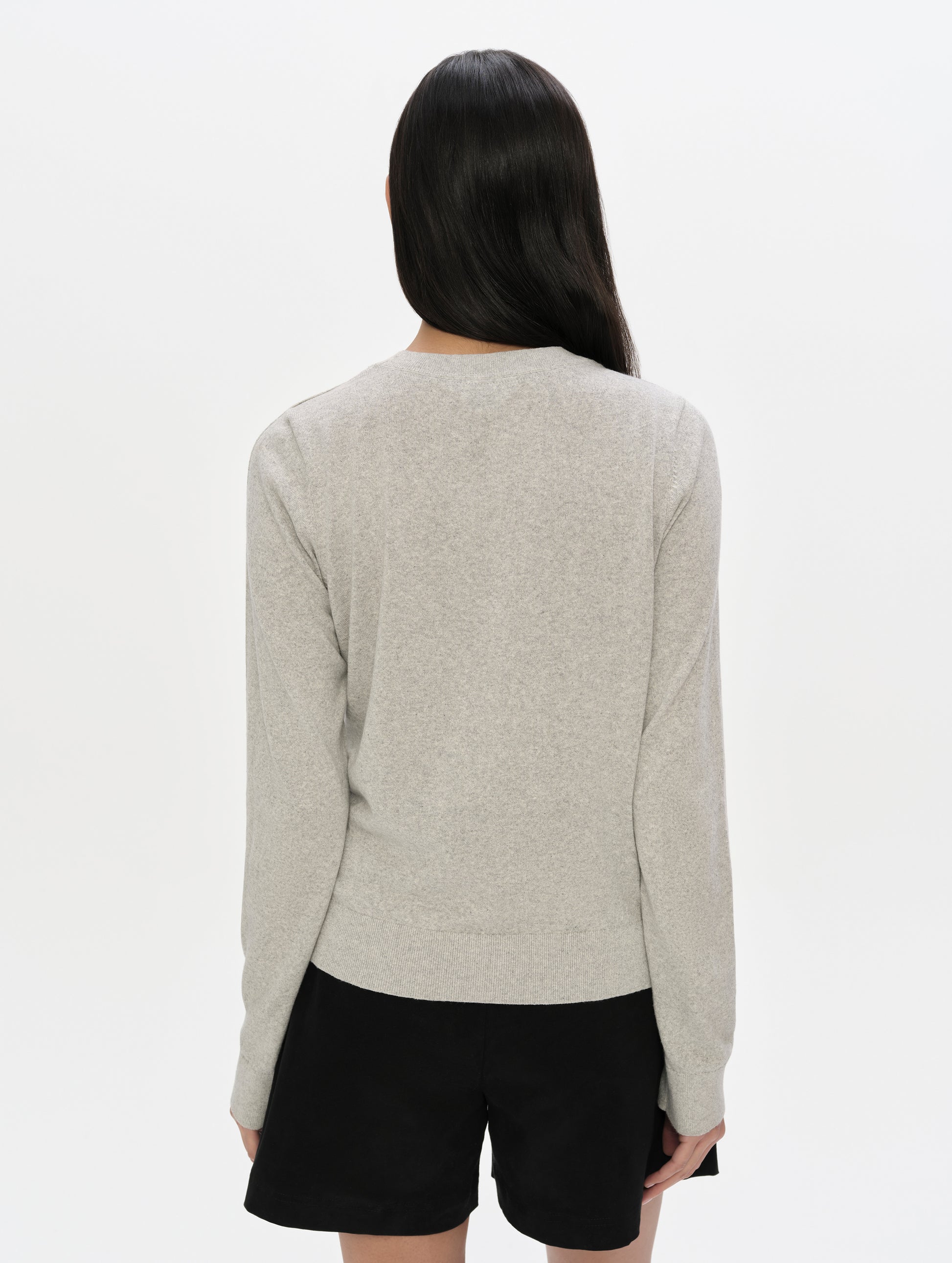 Rear upper-body view of woman wearing the Aero Crewneck Sweater 2.0 in Alumino Grey from AETHER Apparel.