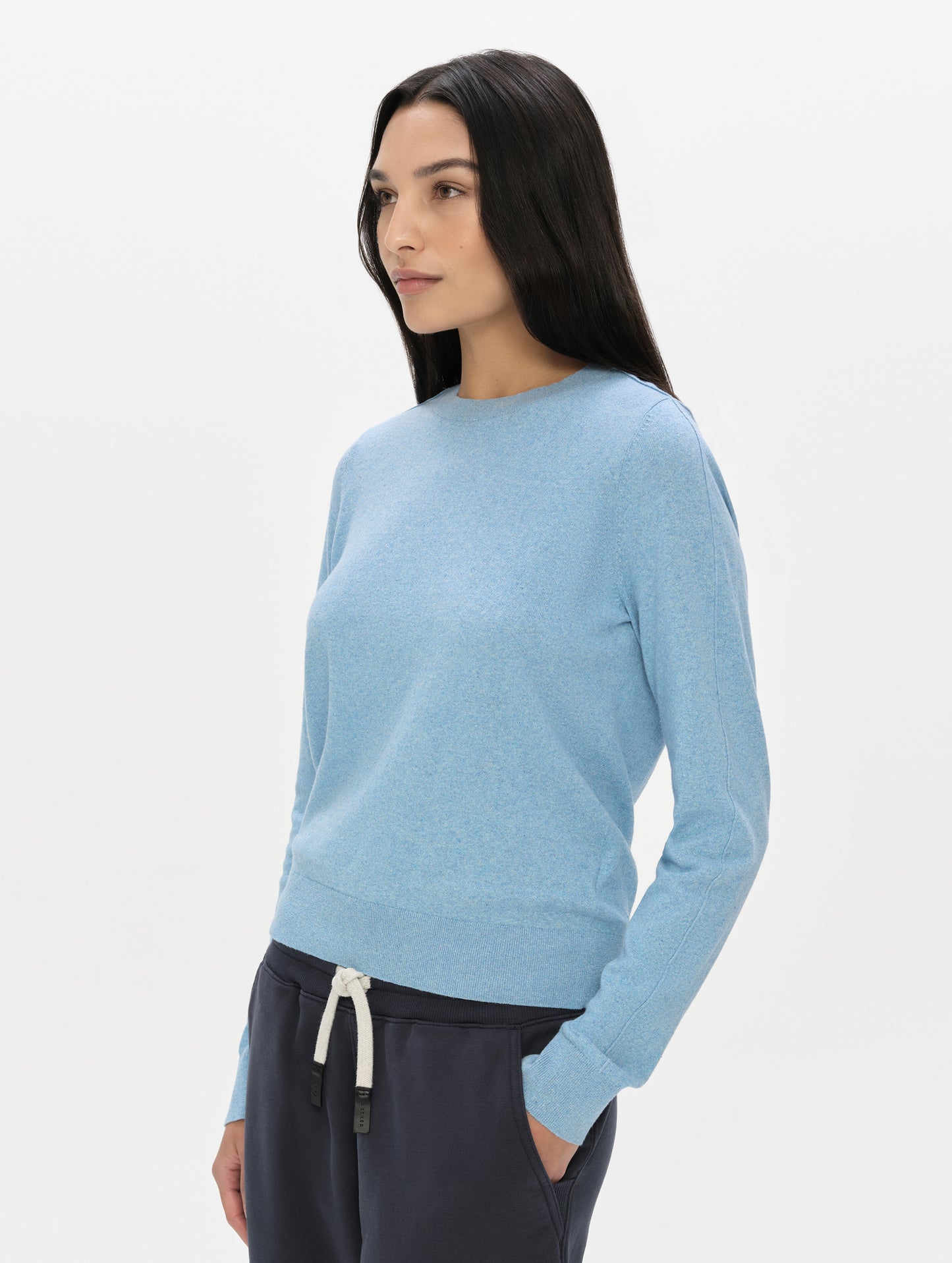 Front, 3/4 upper-body view of woman wearing the Aero Crewneck Sweater 2.0 in Cloud Blue from AETHER Apparel.