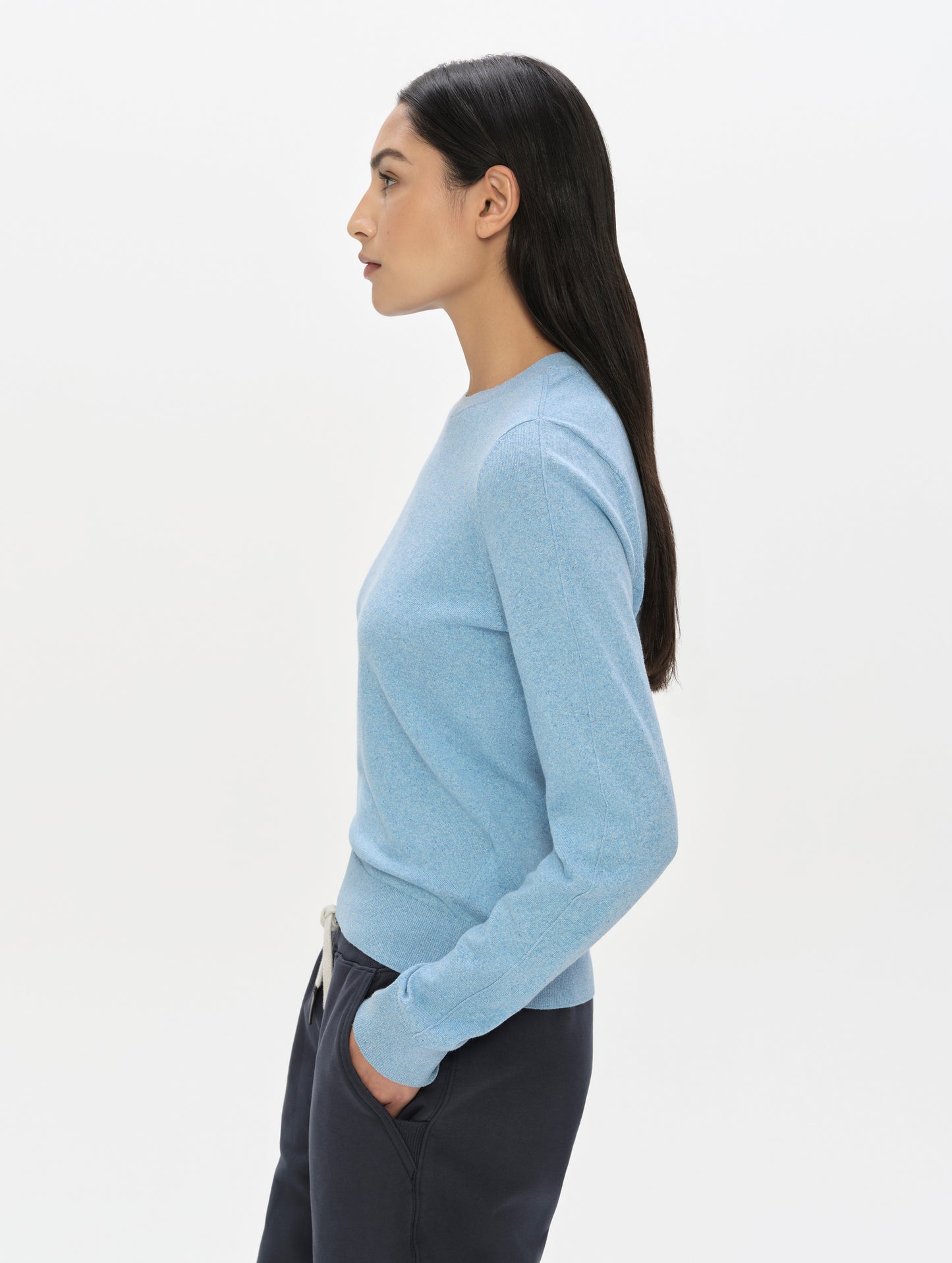 Side profile view of woman wearing the Aero Crewneck Sweater 2.0 in Cloud Blue from AETHER Apparel.