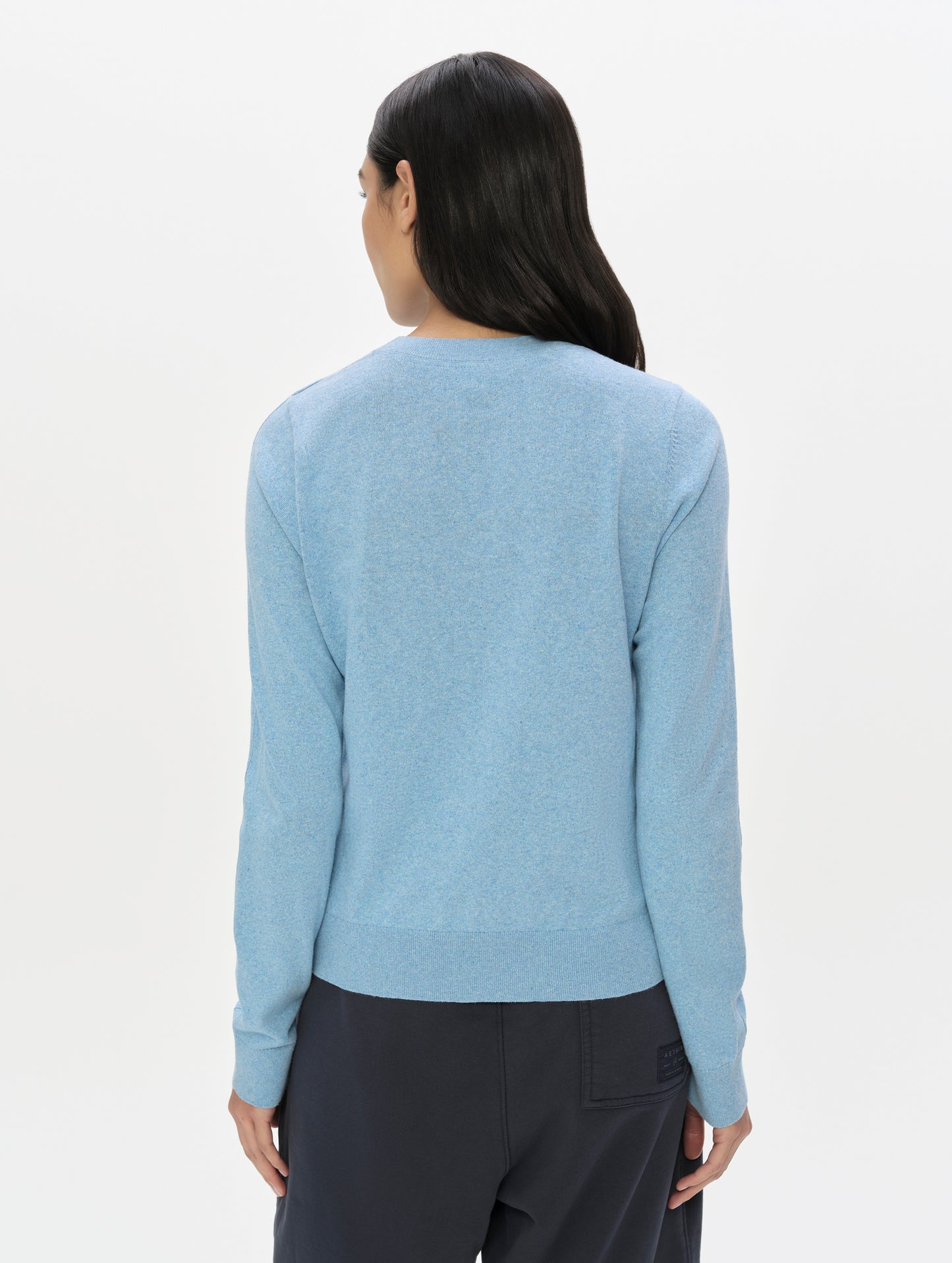 Rear upper-body view of woman wearing the Aero Crewneck Sweater 2.0 in Cloud Blue from AETHER Apparel.