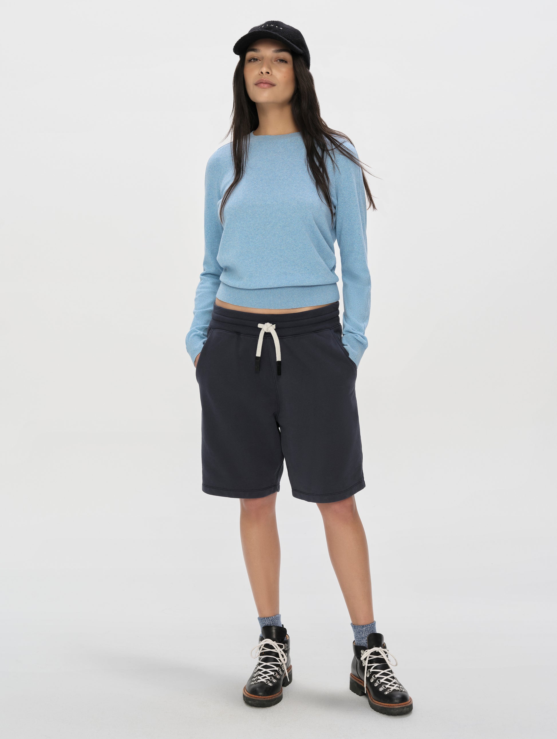 Front, full-body view of woman wearing the Aero Crewneck Sweater 2.0 in Cloud Blue from AETHER Apparel.