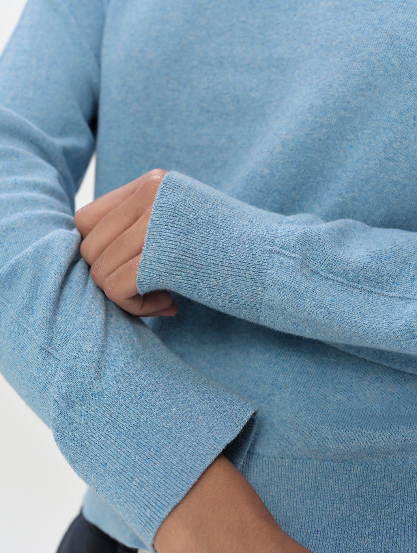 Closeup detailed view of the sleeve cuffs on the women's Aero Crewneck Sweater 2.0 in Cloud Blue from AETHER Apparel.