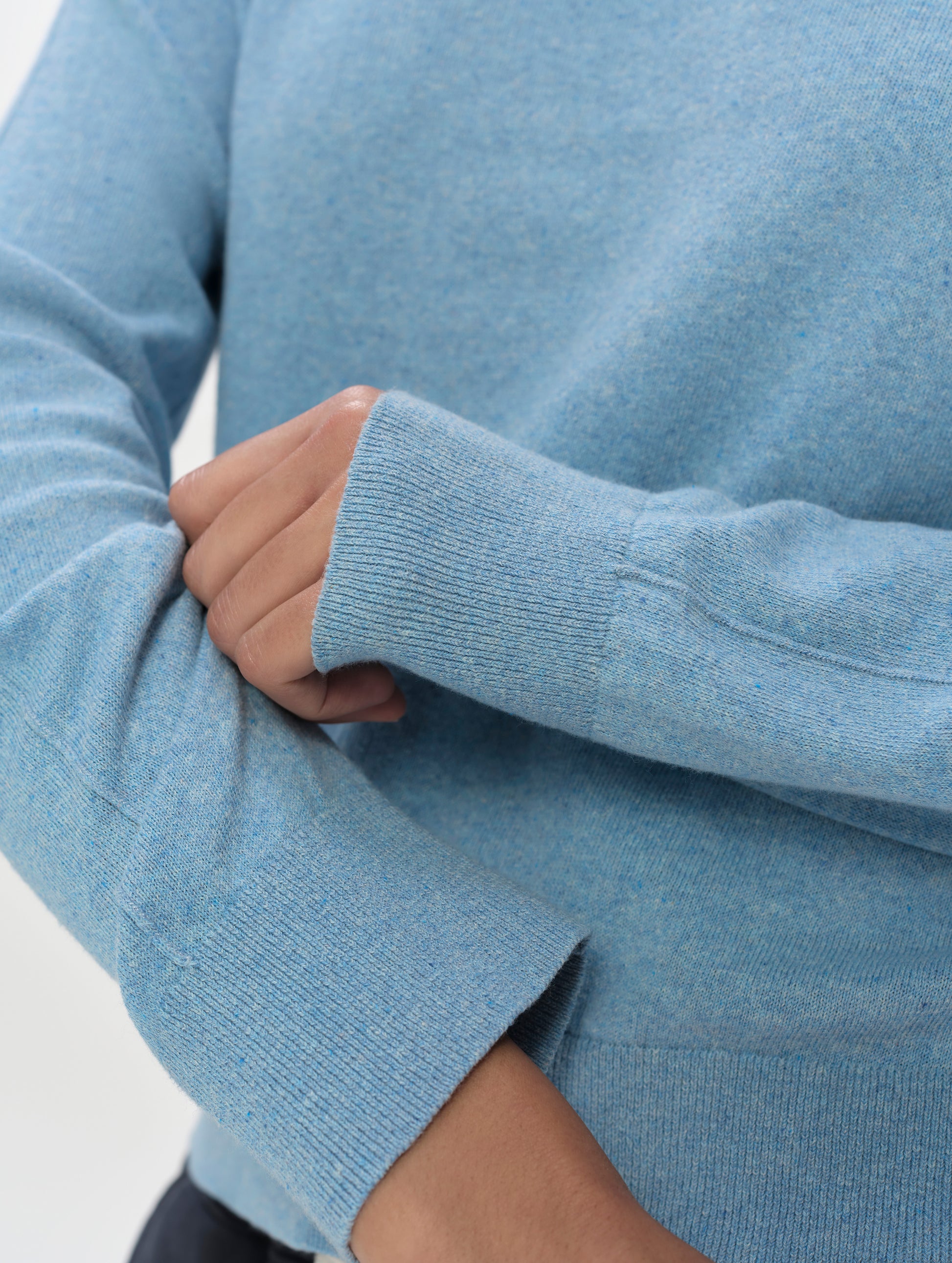 Closeup detailed view of the sleeve cuffs on the women's Aero Crewneck Sweater 2.0 in Cloud Blue from AETHER Apparel.