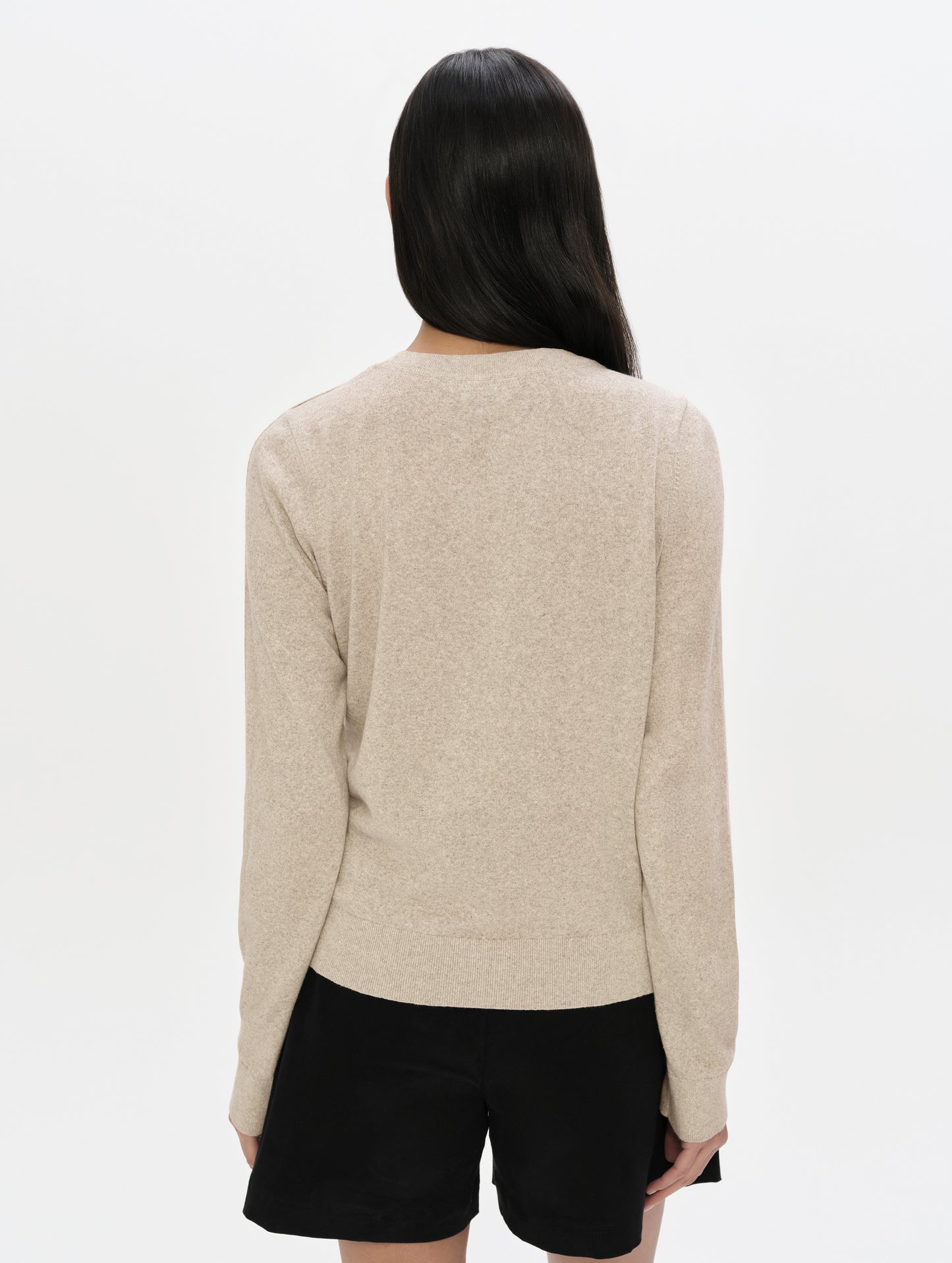 Rear, upper-body view of woman wearing the Aero Crewneck Sweater 2.0 in Lino Tan from AETHER Apparel.