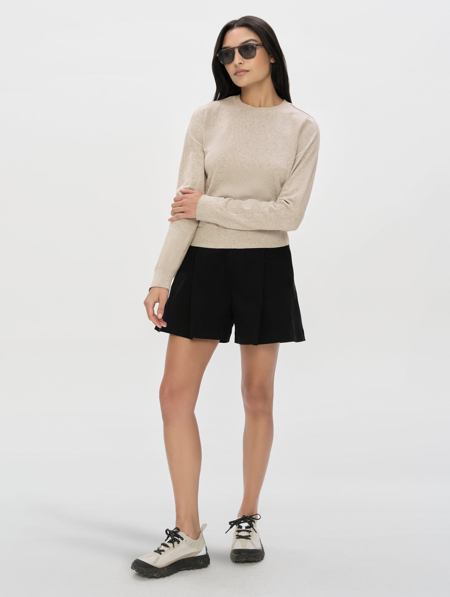 Front, full-body view of woman wearing the Aero Crewneck Sweater 2.0 in Lino Tan from AETHER Apparel.