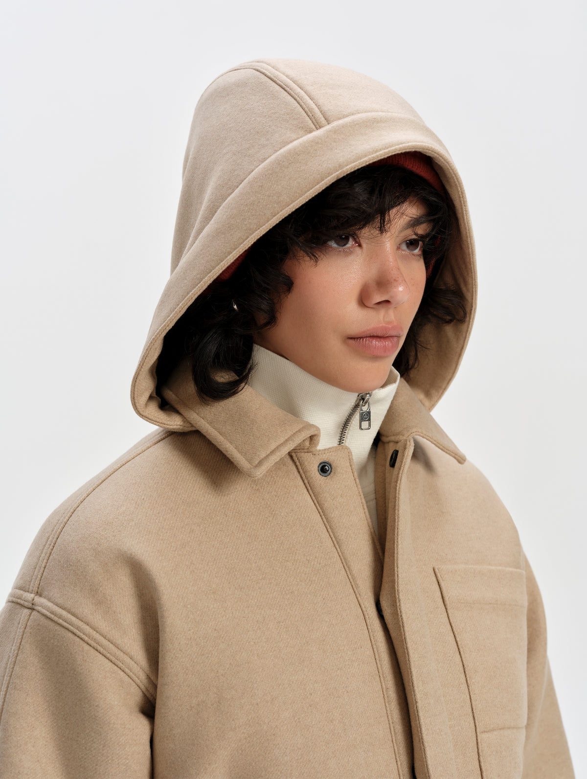 Front 3/4 upper-body view of woman wearing Affina Wool 3-in-1 Overcoat in Latte Brown from AETHER Apparel with the removable hood up. 