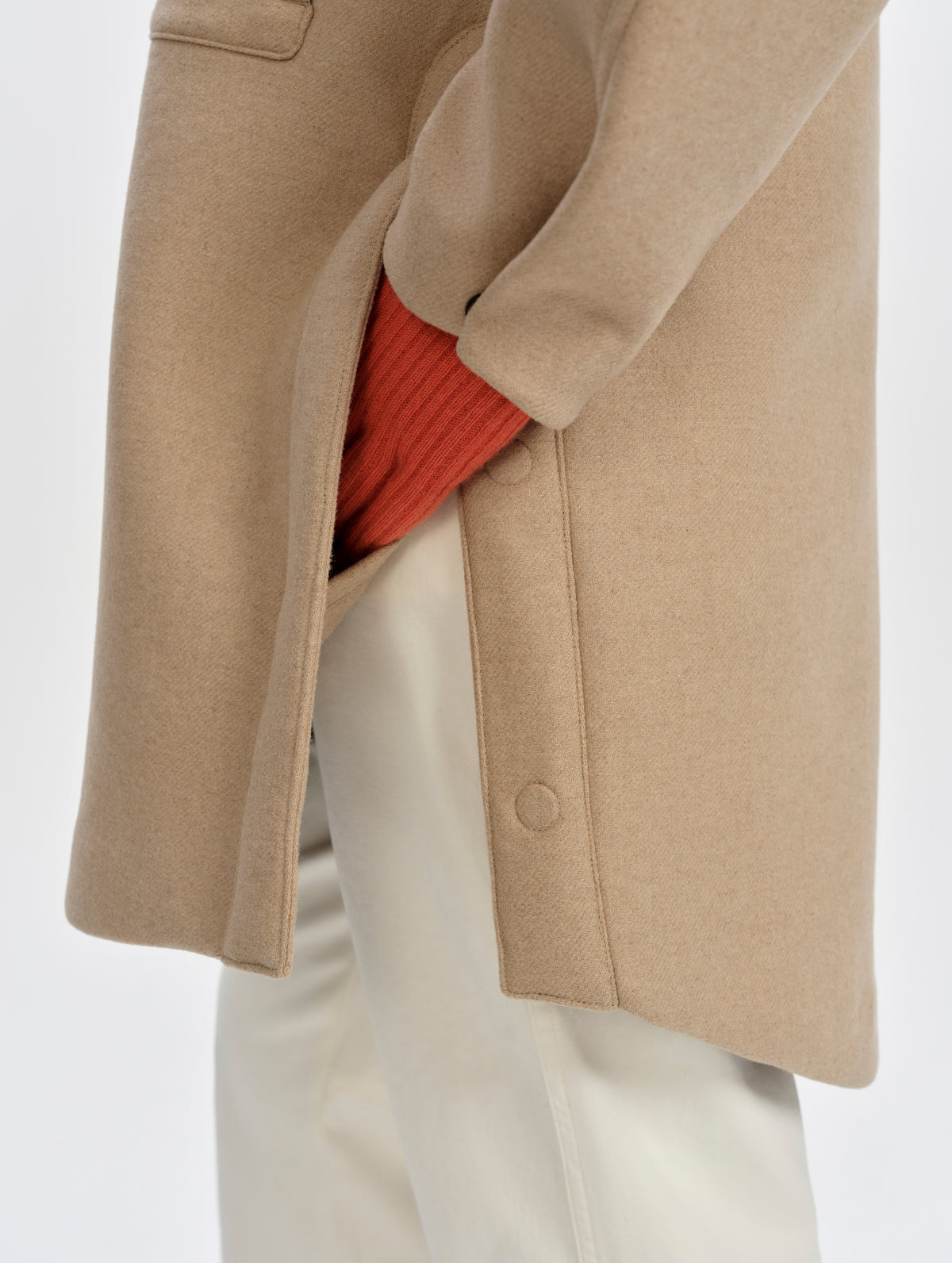 Closeup detailed view of the side slits with metal snap closures on the Affina Wool 3-in-1 Overcoat in Latte Brown from AETHER Apparel.