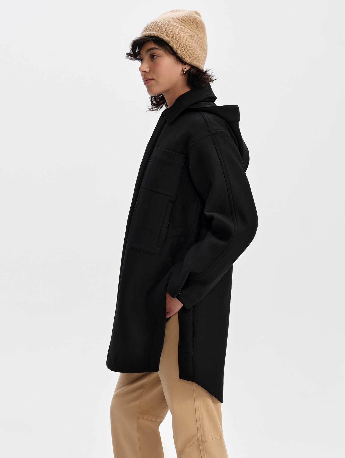 Side profile upper-body view of woman wearing Affina Wool 3-in-1 Overcoat in Onyx Black from AETHER Apparel.