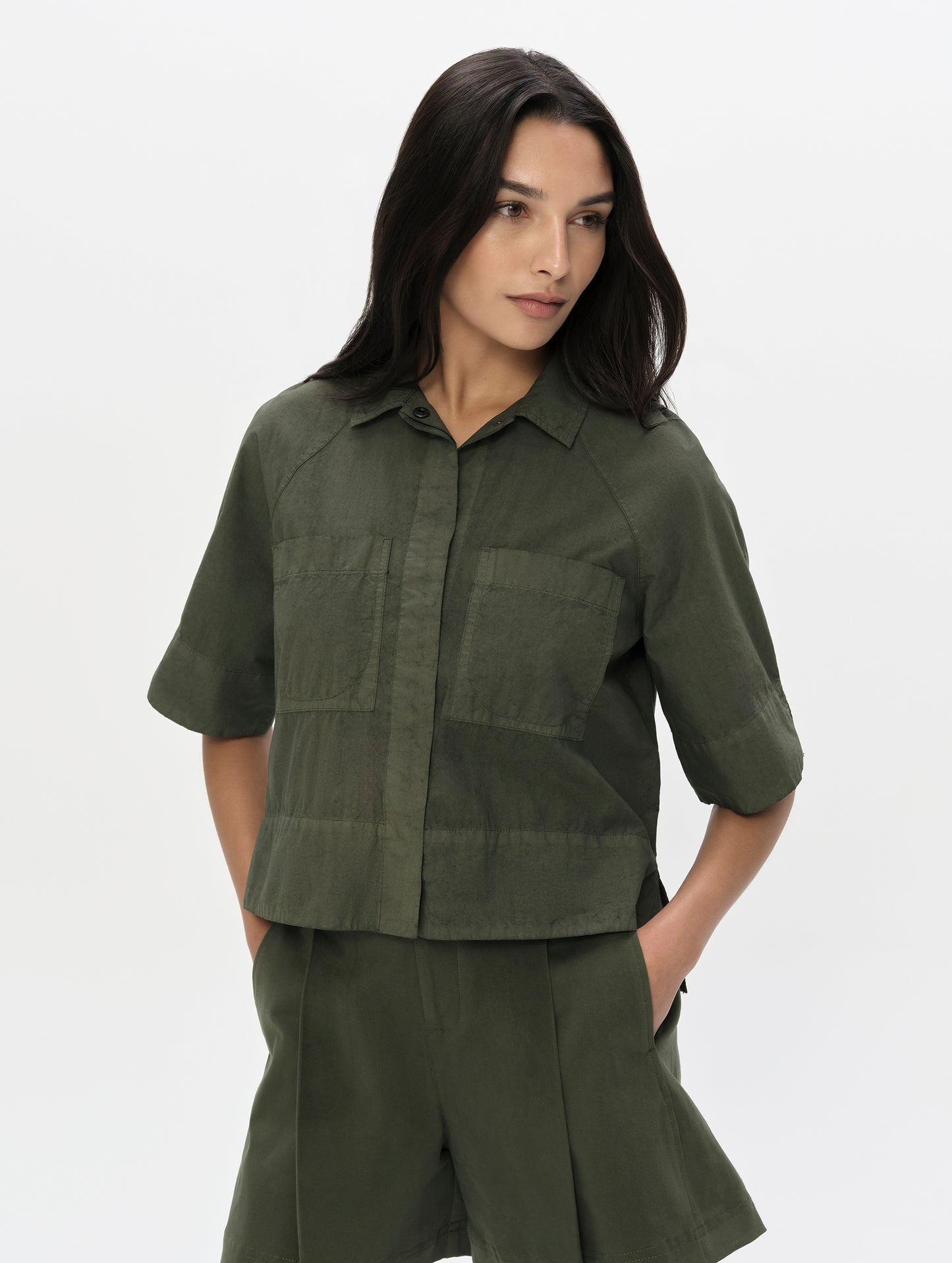 Front upper body view of woman wearing the Alice Shirt in Forest Green from AETHER Apparel.