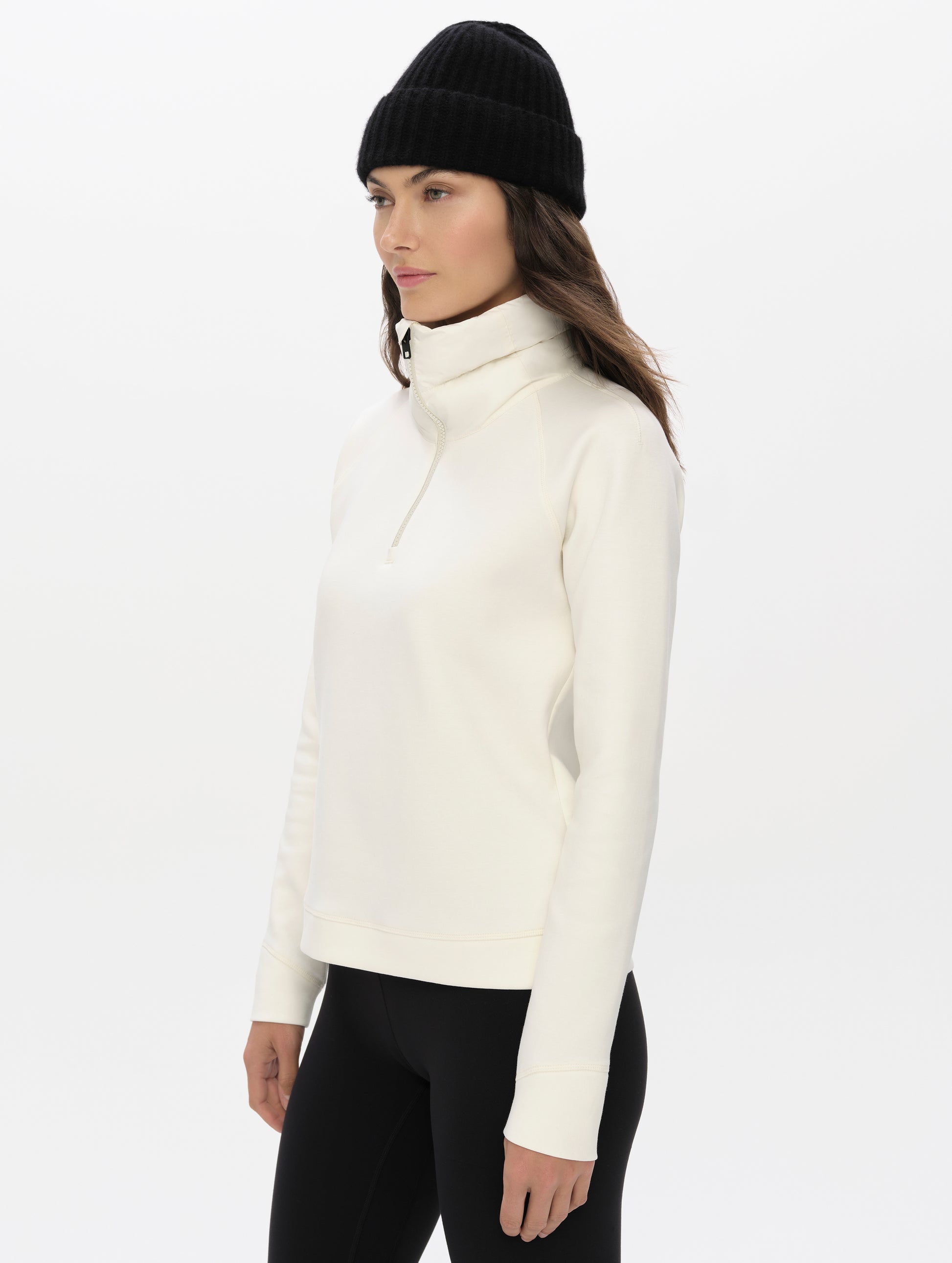 Front, 3/4, upper-body view of woman wearing the Align Half-Zip Pullover in Winter White from AETHER Apparel.