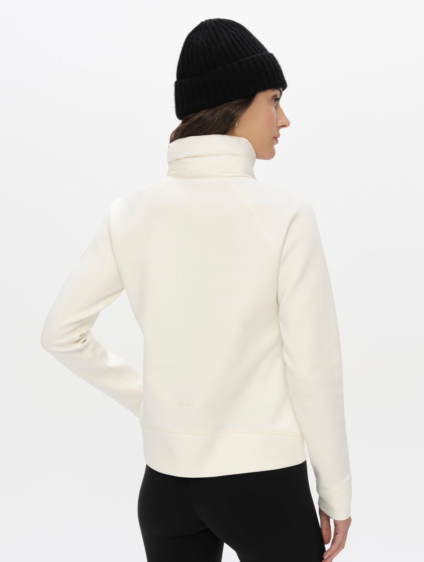 Rear angled upper-body view of woman wearing the Align Half-Zip Pullover in Winter White from AETHER Apparel.
