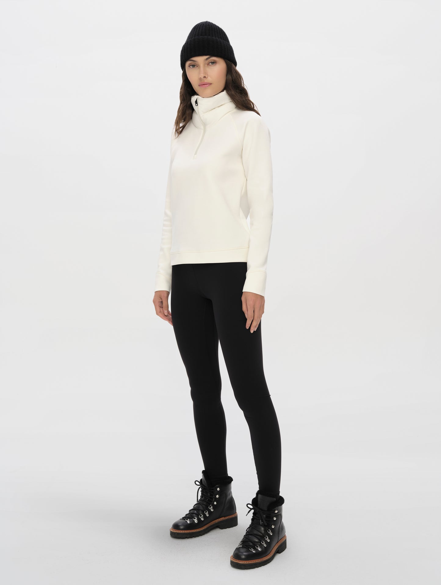 Front, 3/4, full-body view of woman wearing the Align Half-Zip Pullover in Winter White from AETHER Apparel.