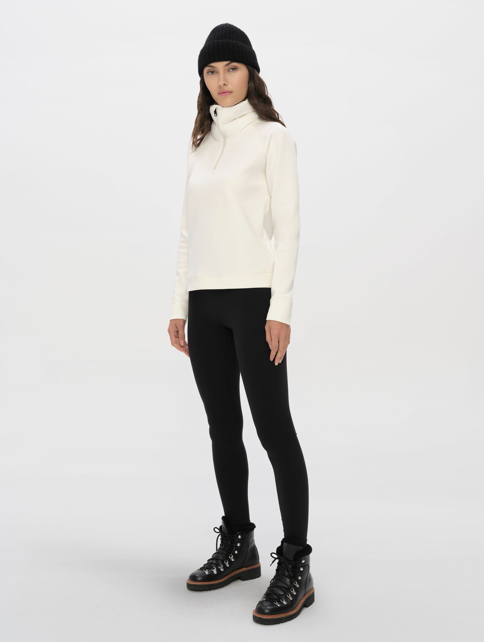 Front, 3/4, full-body view of woman wearing the Align Half-Zip Pullover in Winter White from AETHER Apparel.